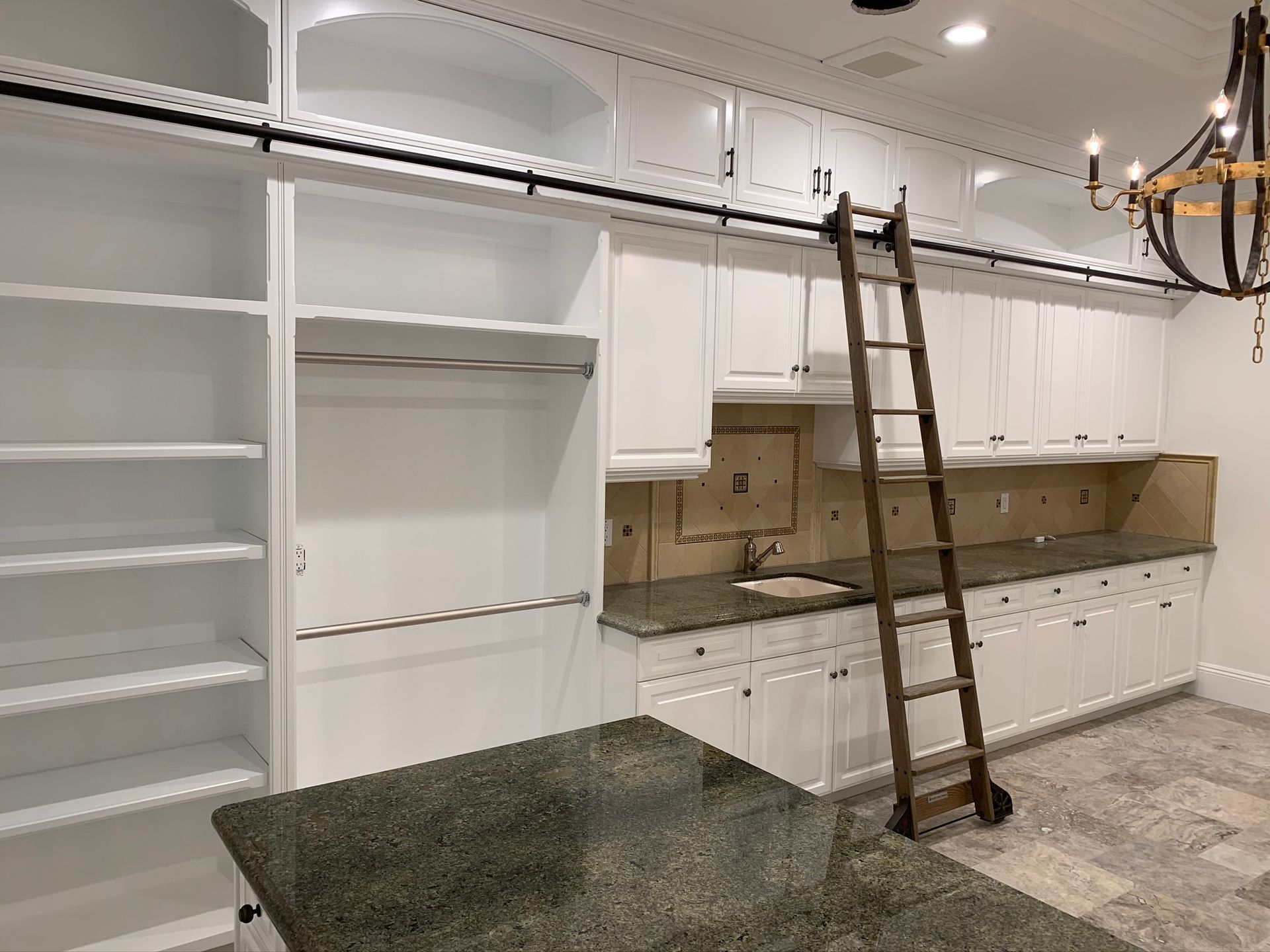 Wooden cabinetry in a kitchen area with a countertop, appliances, and a small bar with seating.