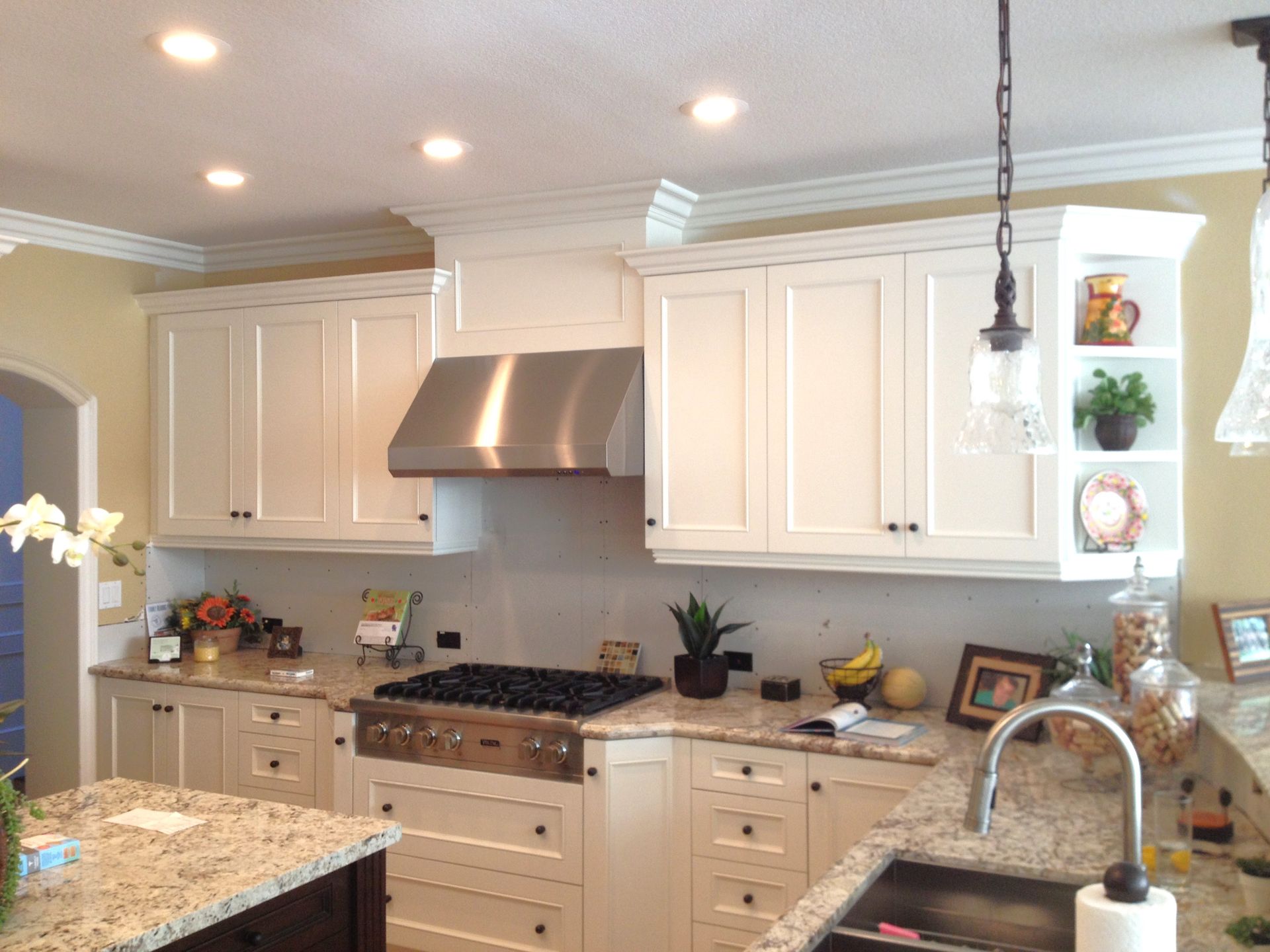 White kitchen with stainless steel appliances, granite countertops, and light cabinets.