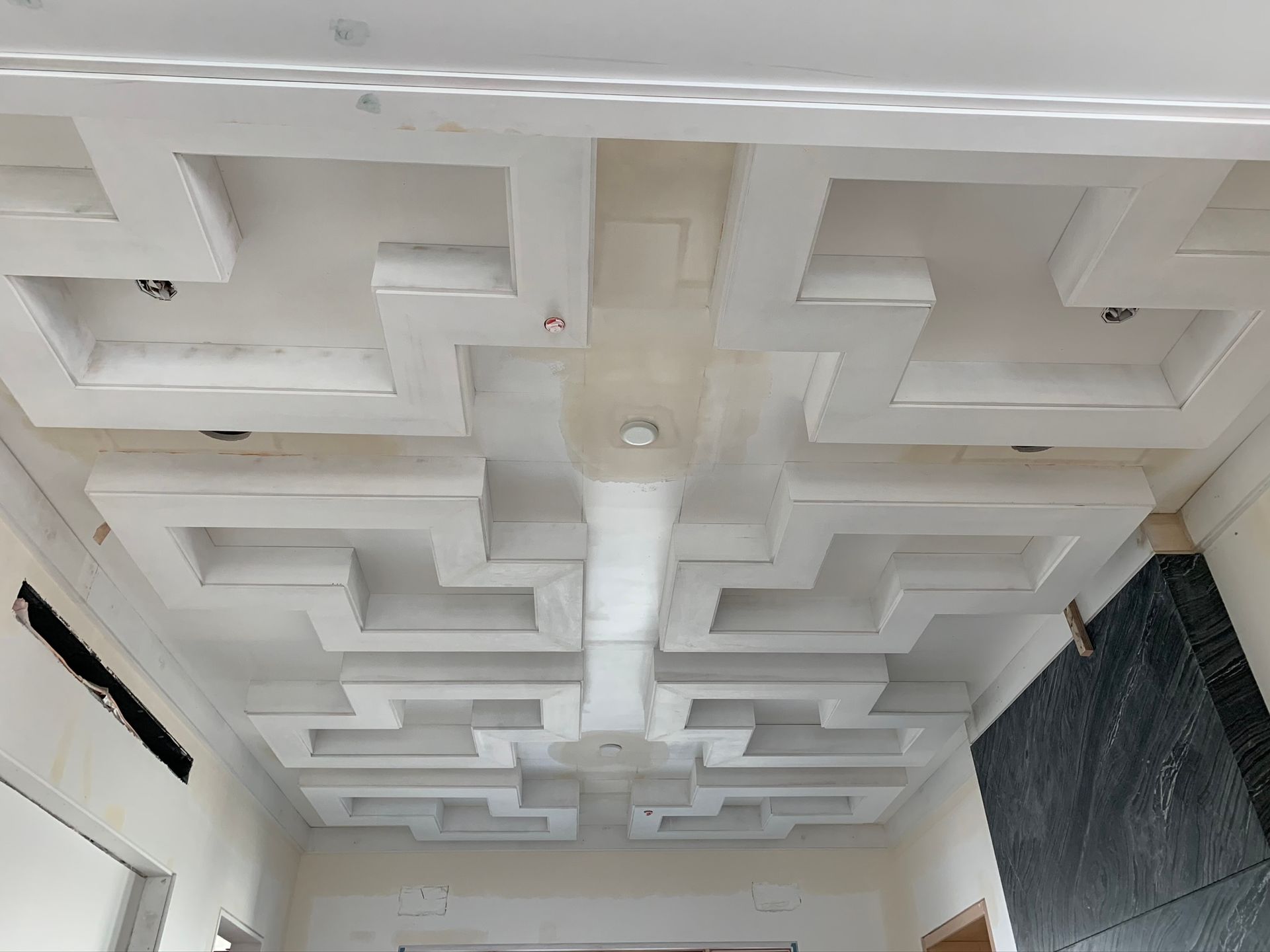 Wooden bar inside a dimly lit space with bottles, taps, and arcade game visible.