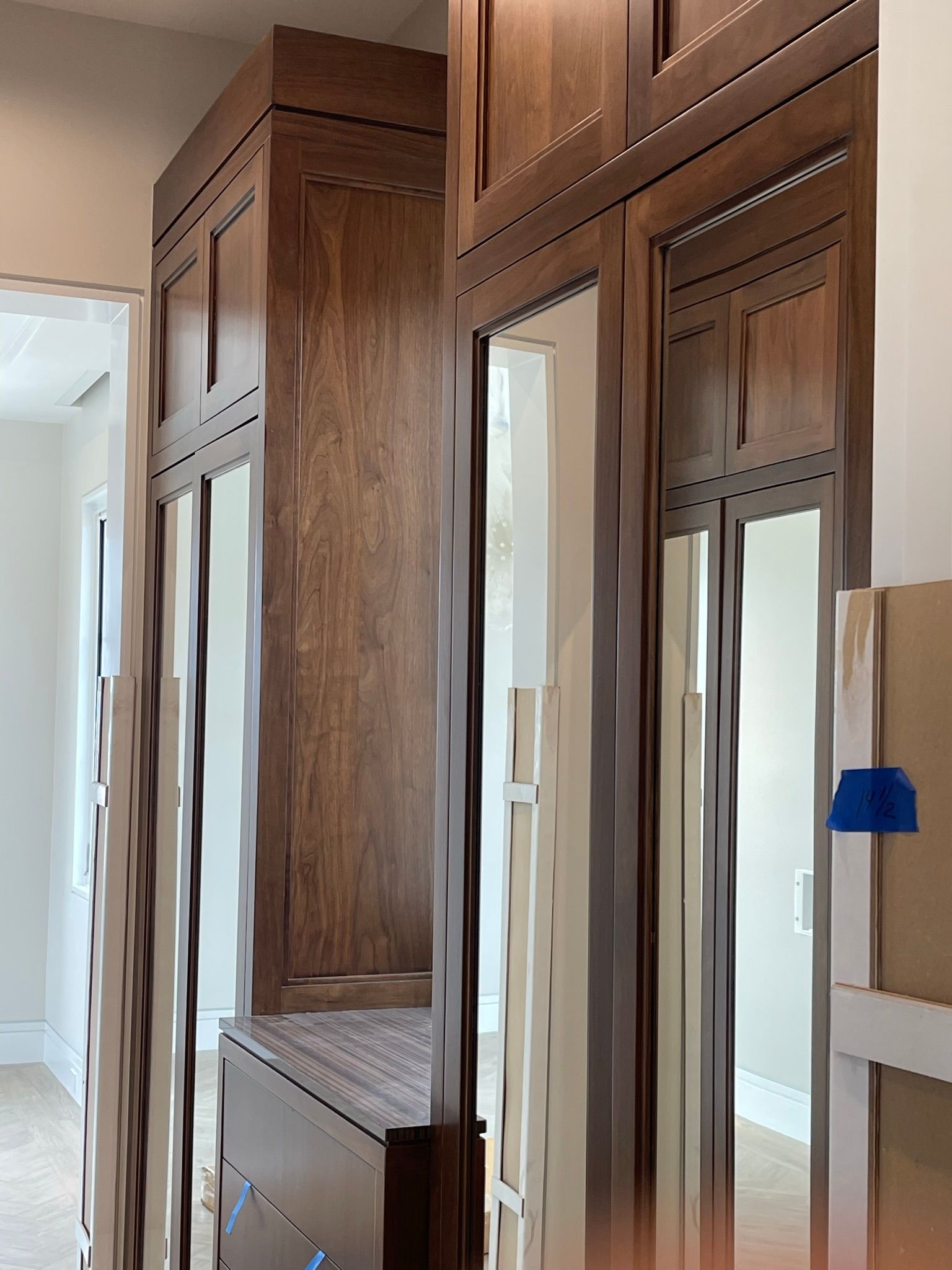 Wooden cabinets with mirrored doors, in a hallway.