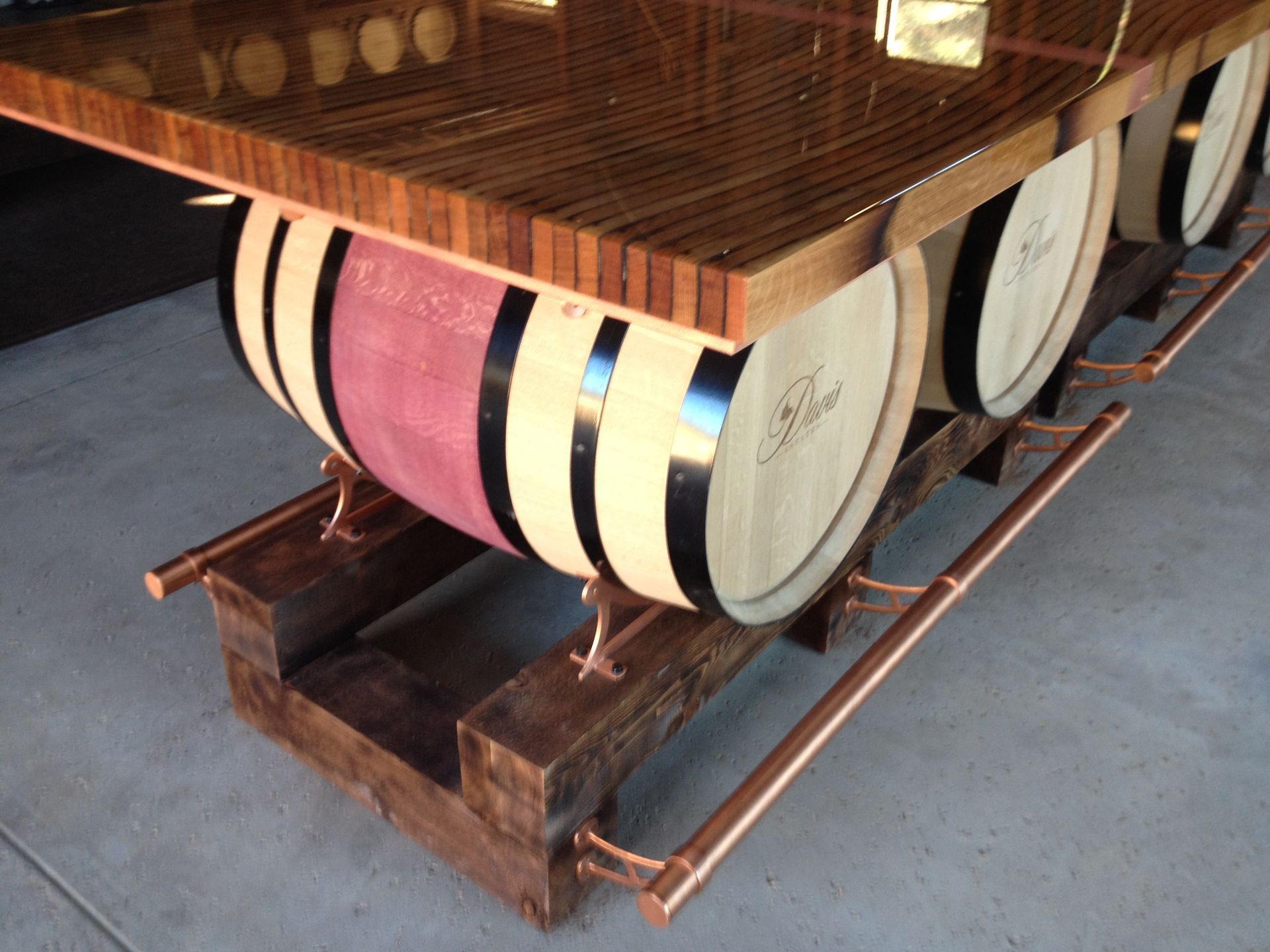 Wooden bar supported by wine barrels. Copper piping and wooden base.