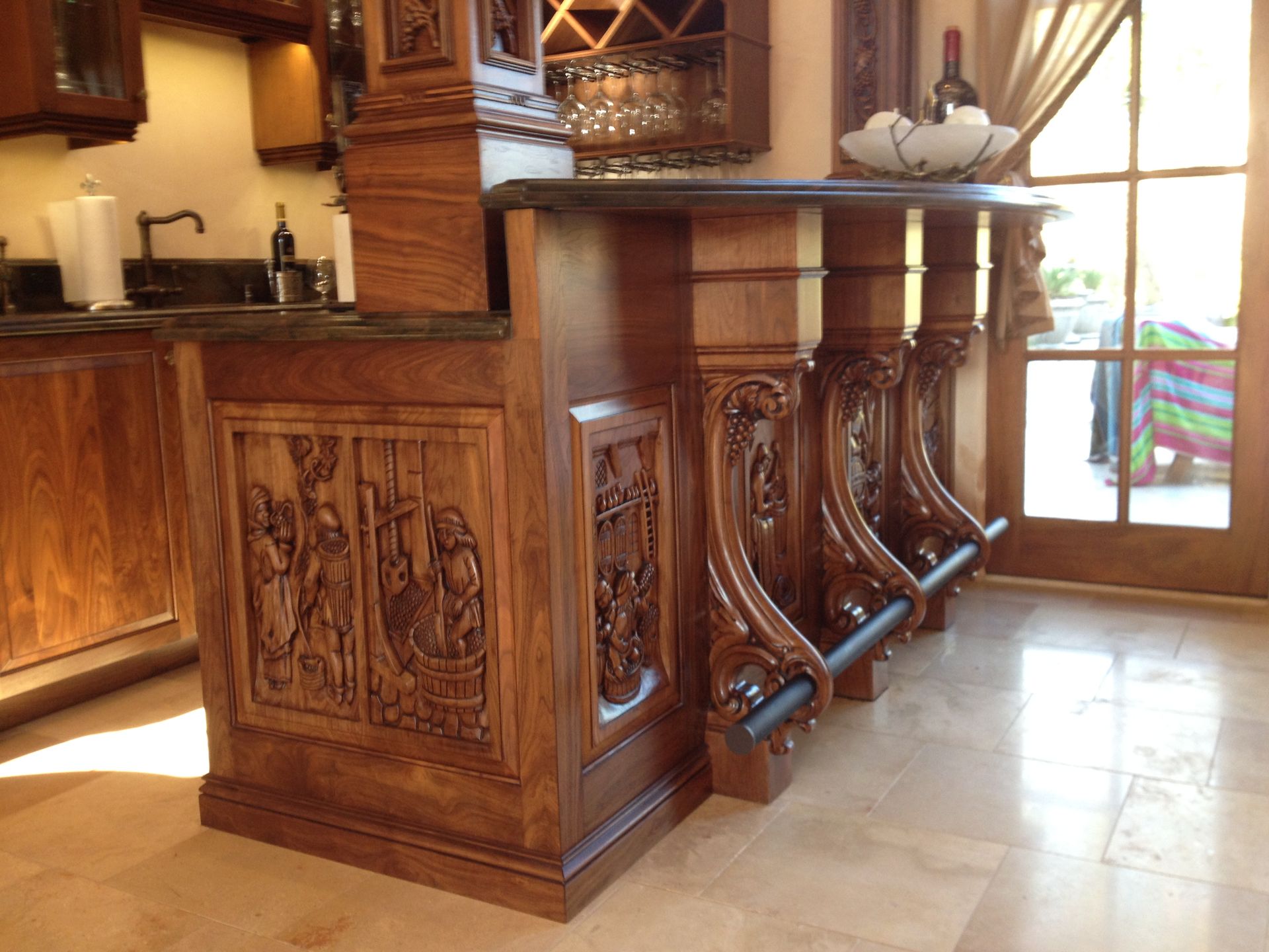 Ornate wooden bar with carved panels, dark countertop, and decorative support beams.