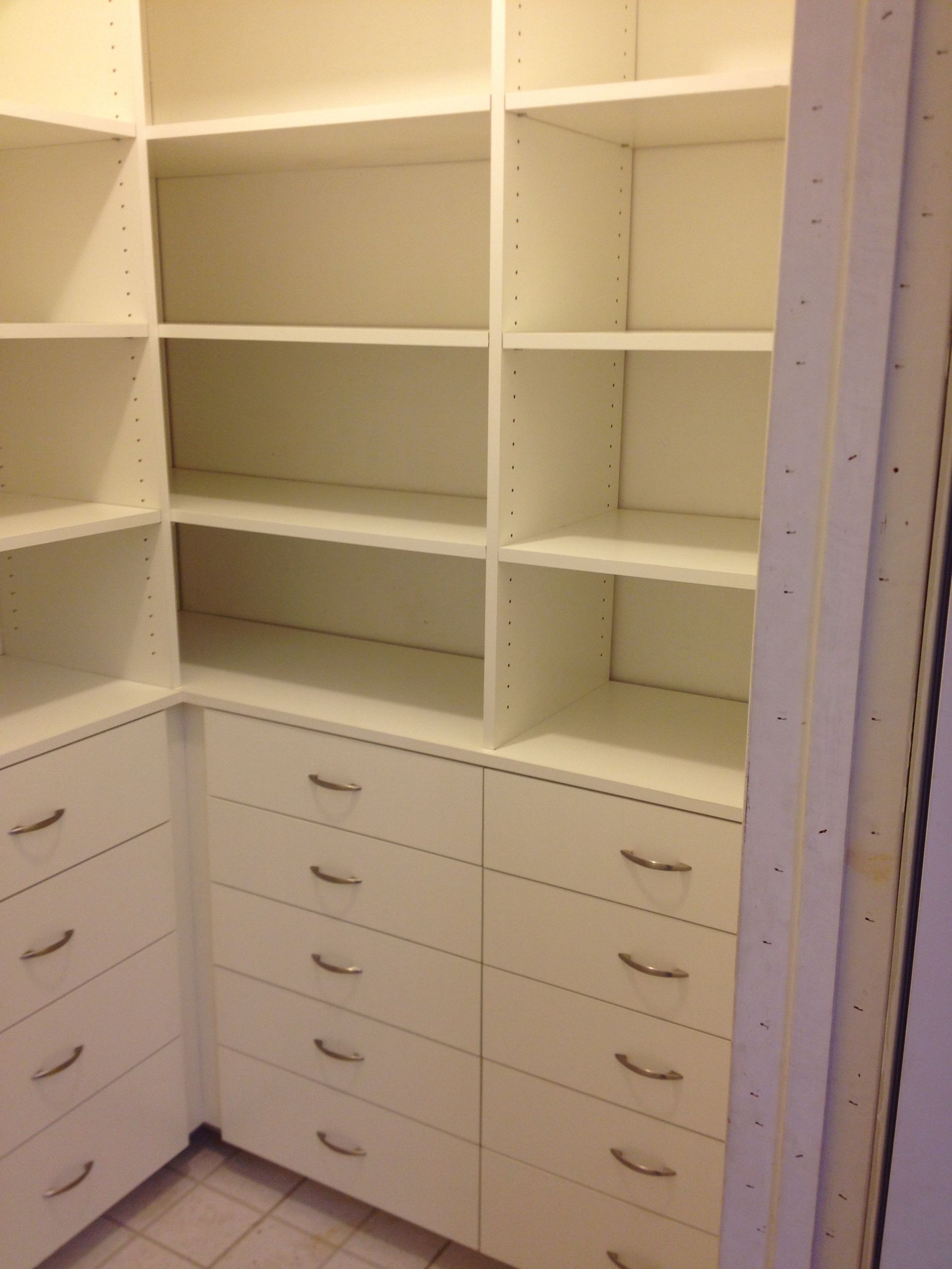 White walk-in closet with shelves and drawers. Chrome drawer pulls. Empty.