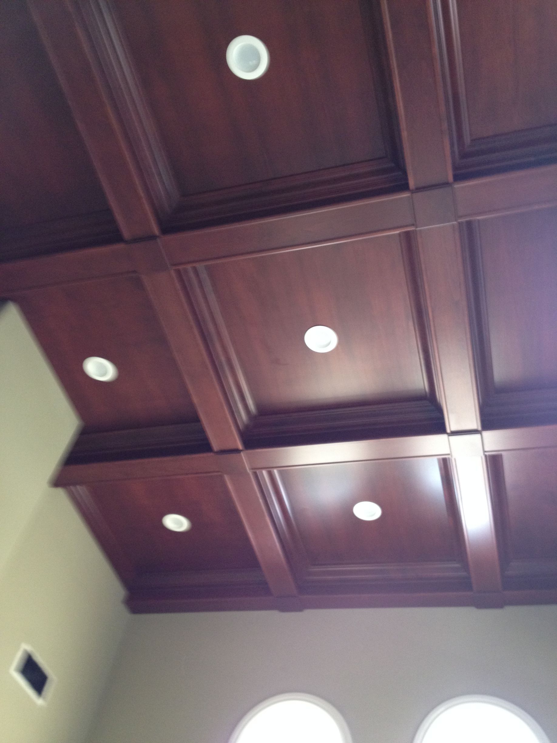 Wooden coffered ceiling with recessed lights.