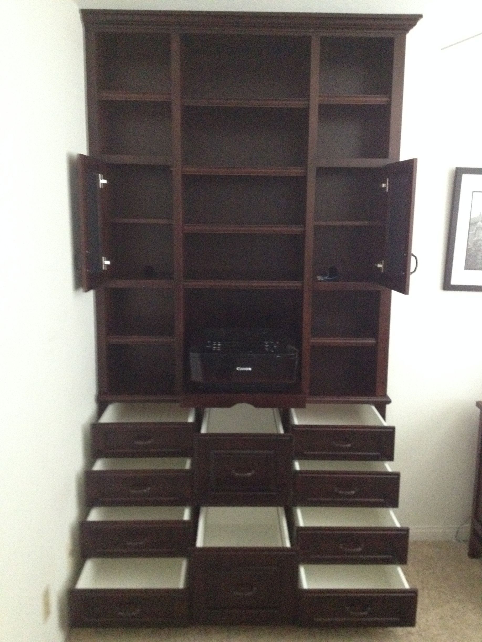 Dark brown wooden entertainment center with open doors, drawers, and shelving.