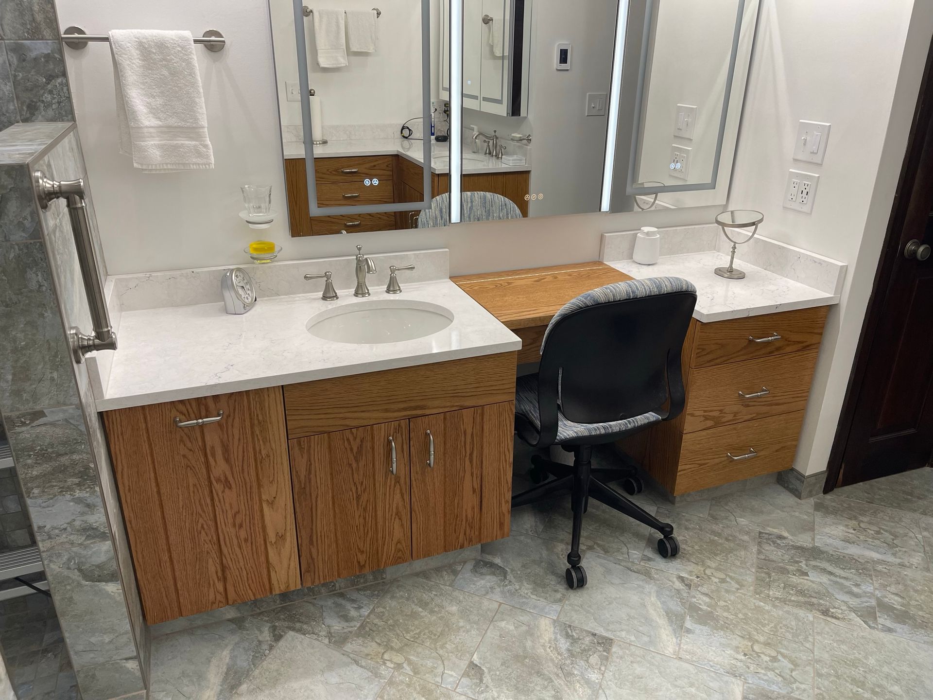 Bathroom with a vanity and sink, wood cabinets, and large mirror.