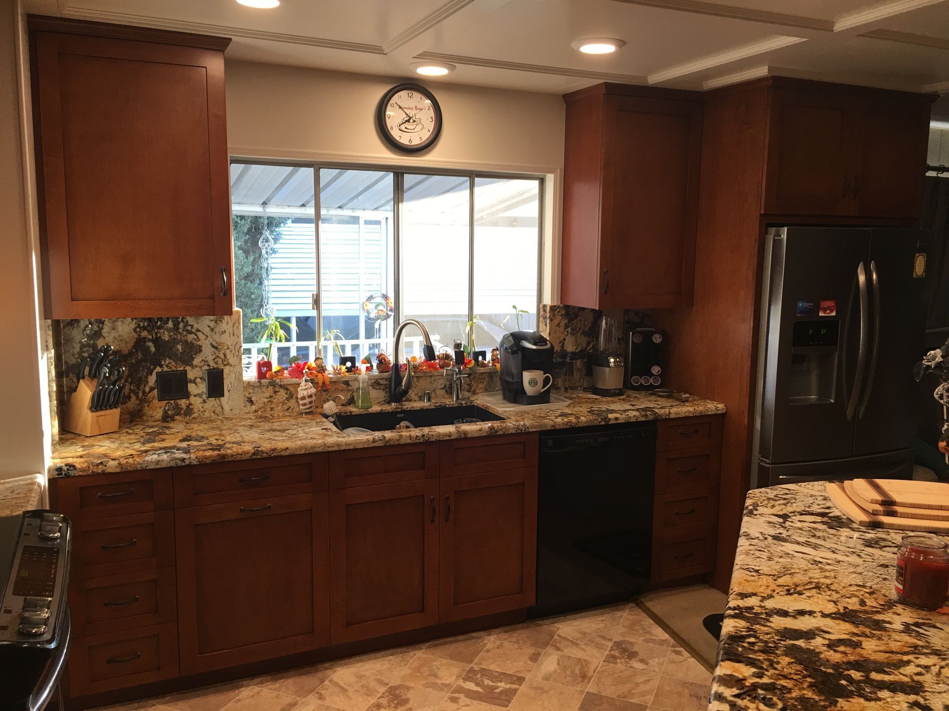 Kitchen with wood cabinets, granite countertops, and a window over the sink.