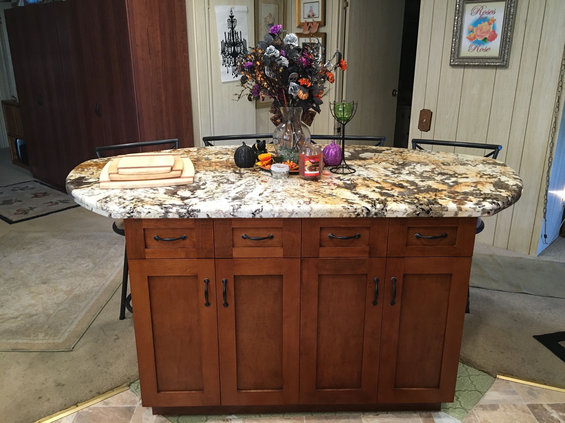 Kitchen island with granite countertop, wooden cabinets, and Halloween decorations.