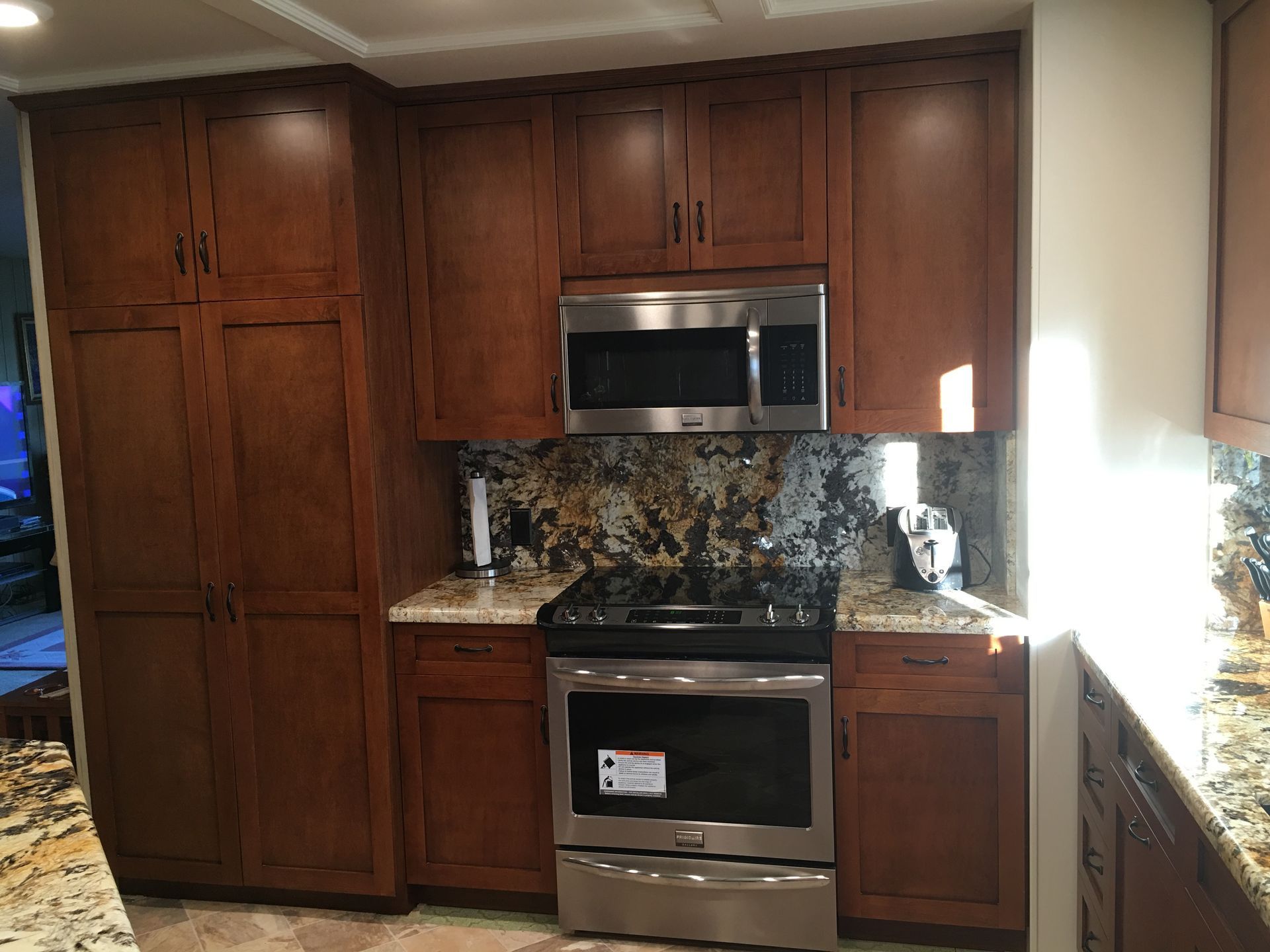 Kitchen with dark wood cabinets, stainless steel appliances, and granite countertops.