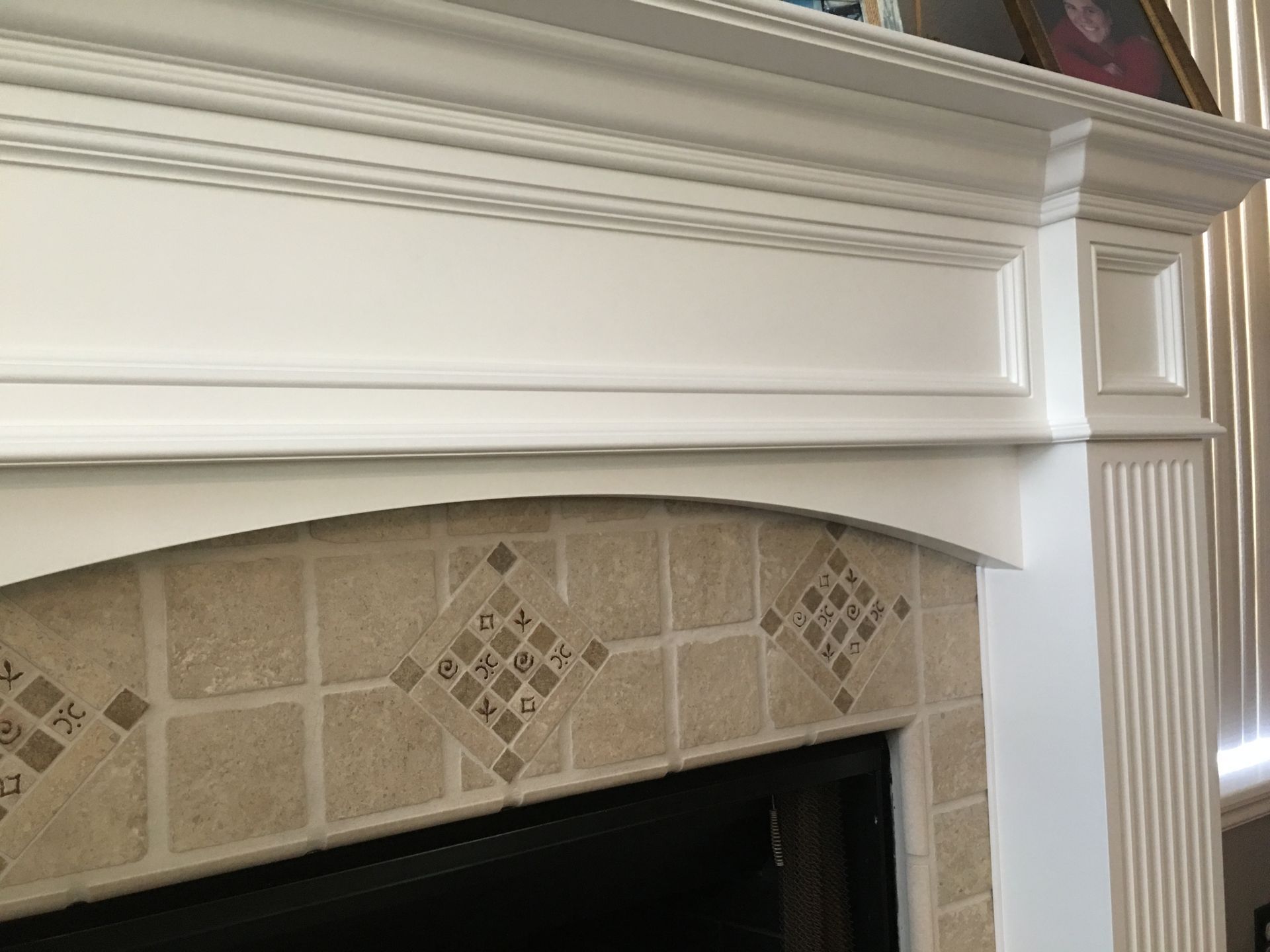 White fireplace mantel with decorative tile surround.