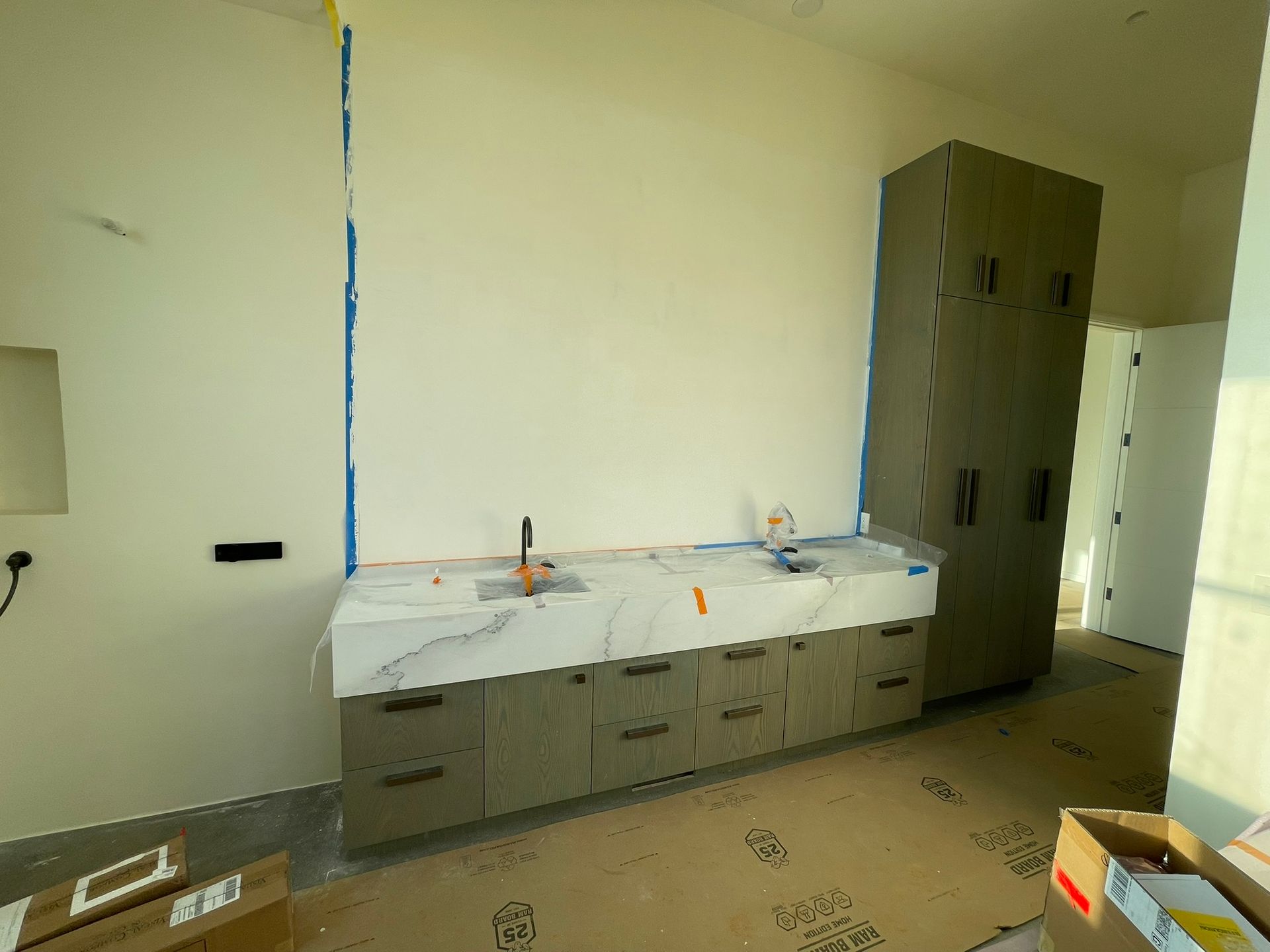 Bathroom with a gray cabinet, marble countertop, and tall matching cabinet.