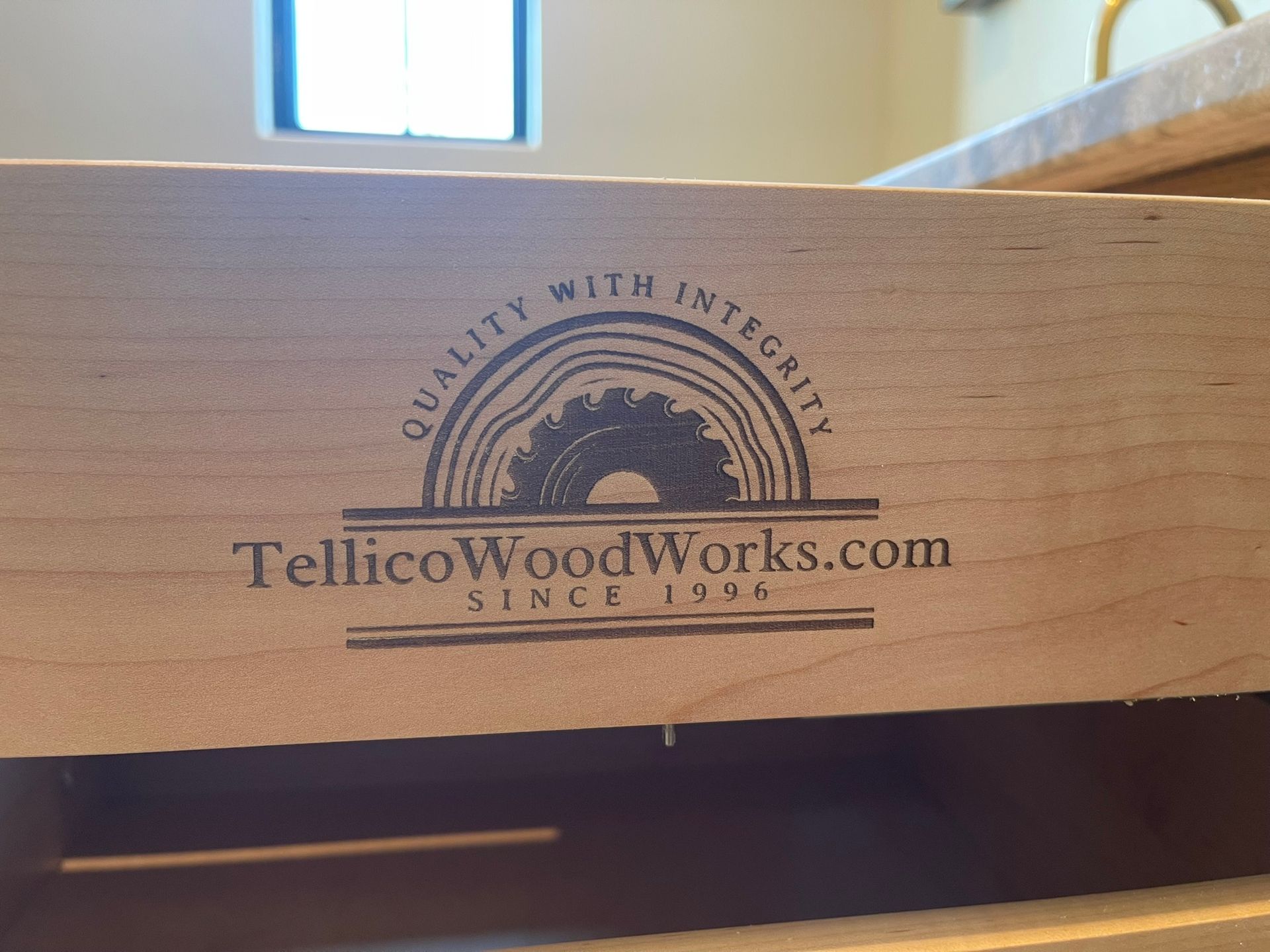 Logo on wooden drawer: Tellico Woodworks, with a saw blade design, 