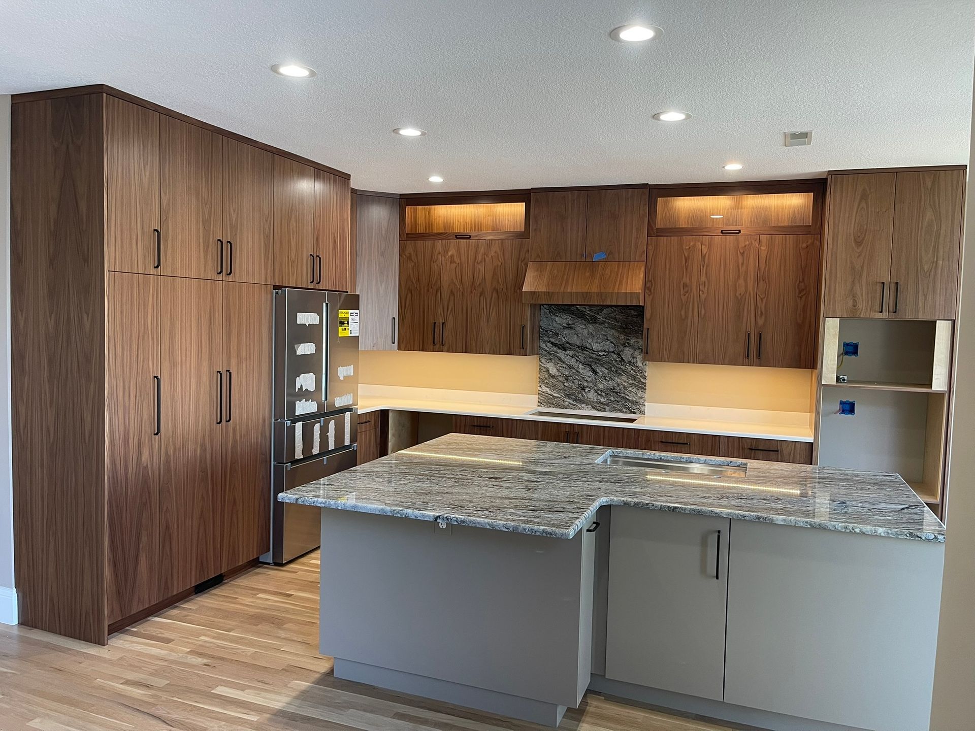 Modern kitchen with wood cabinets, granite countertops, and an island.