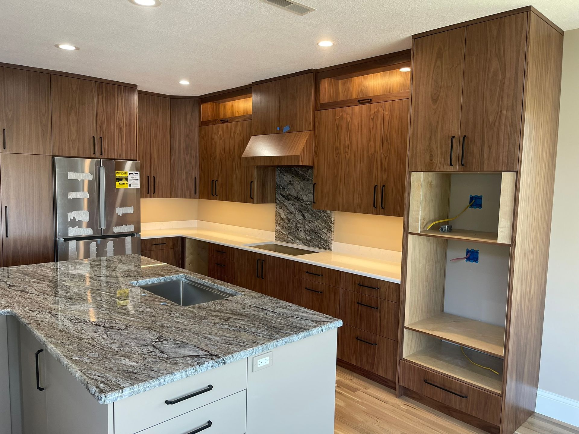 Modern kitchen with wood cabinets, granite countertops, and stainless steel appliances.