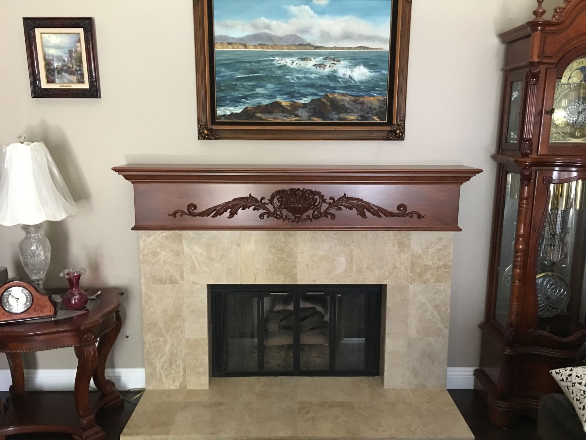 Fireplace with marble surround, wood mantel, and artwork above. 