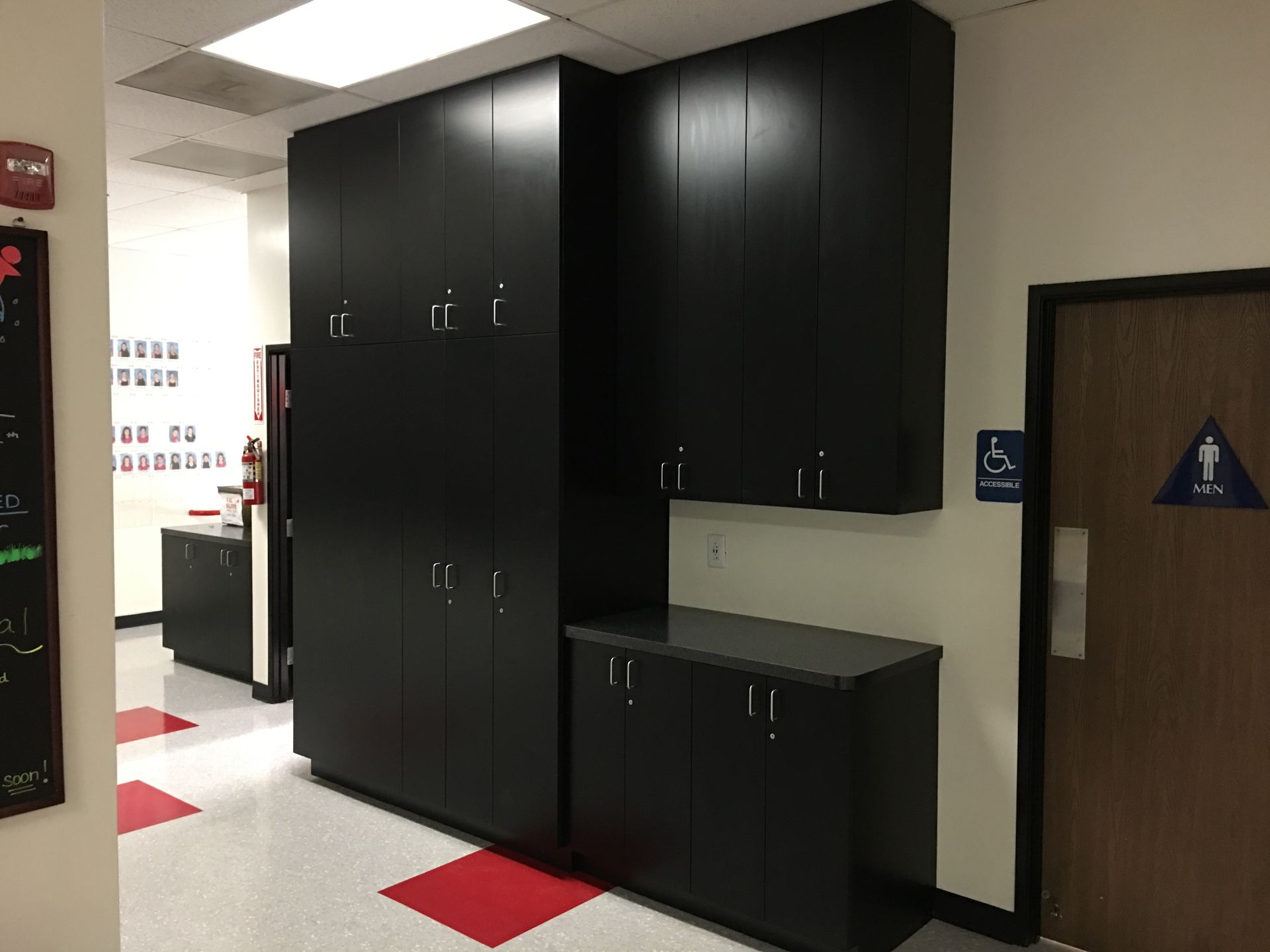 Black storage cabinets and counter in hallway.