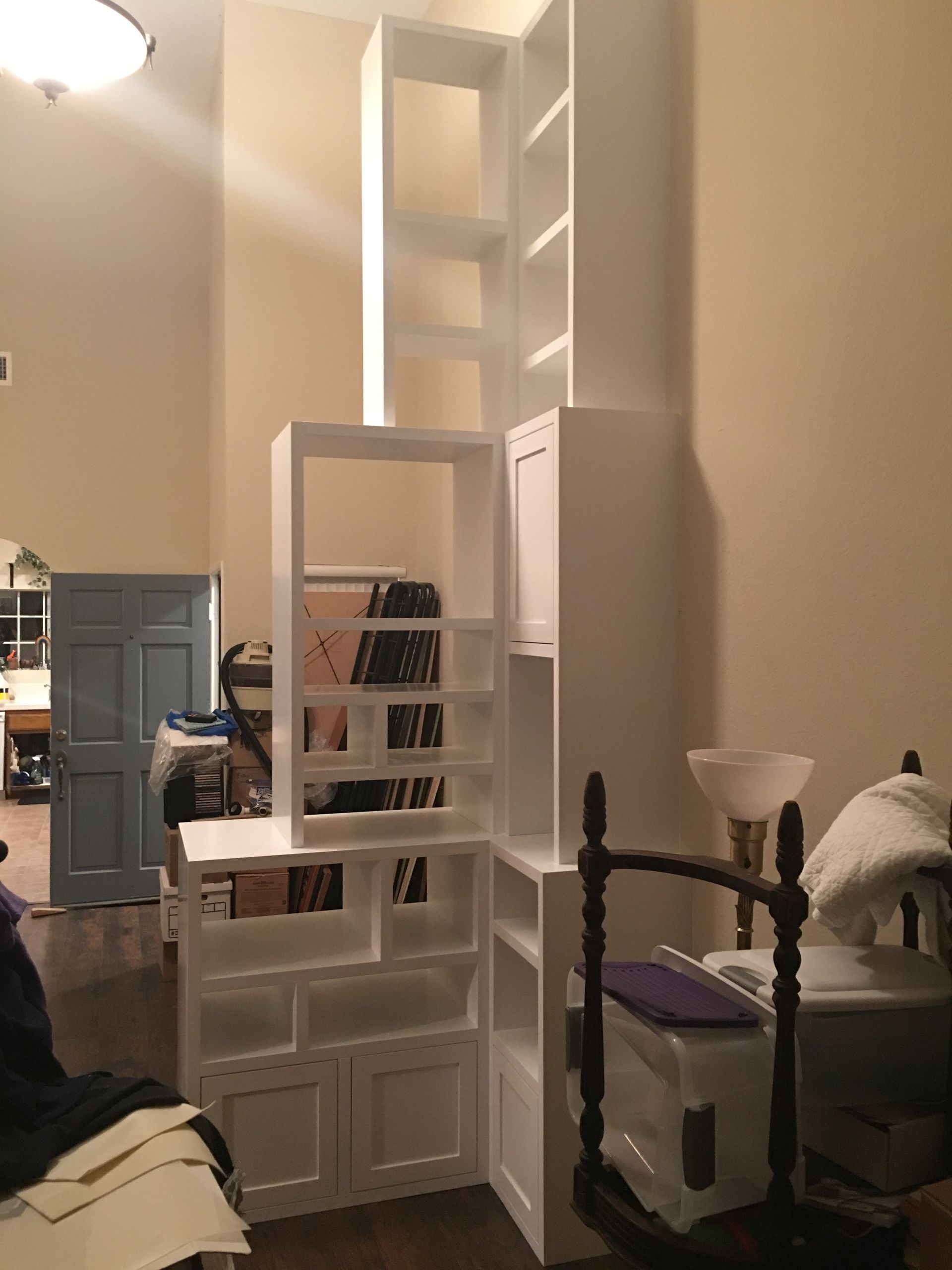 White built-in shelving unit, spanning corner of room. 