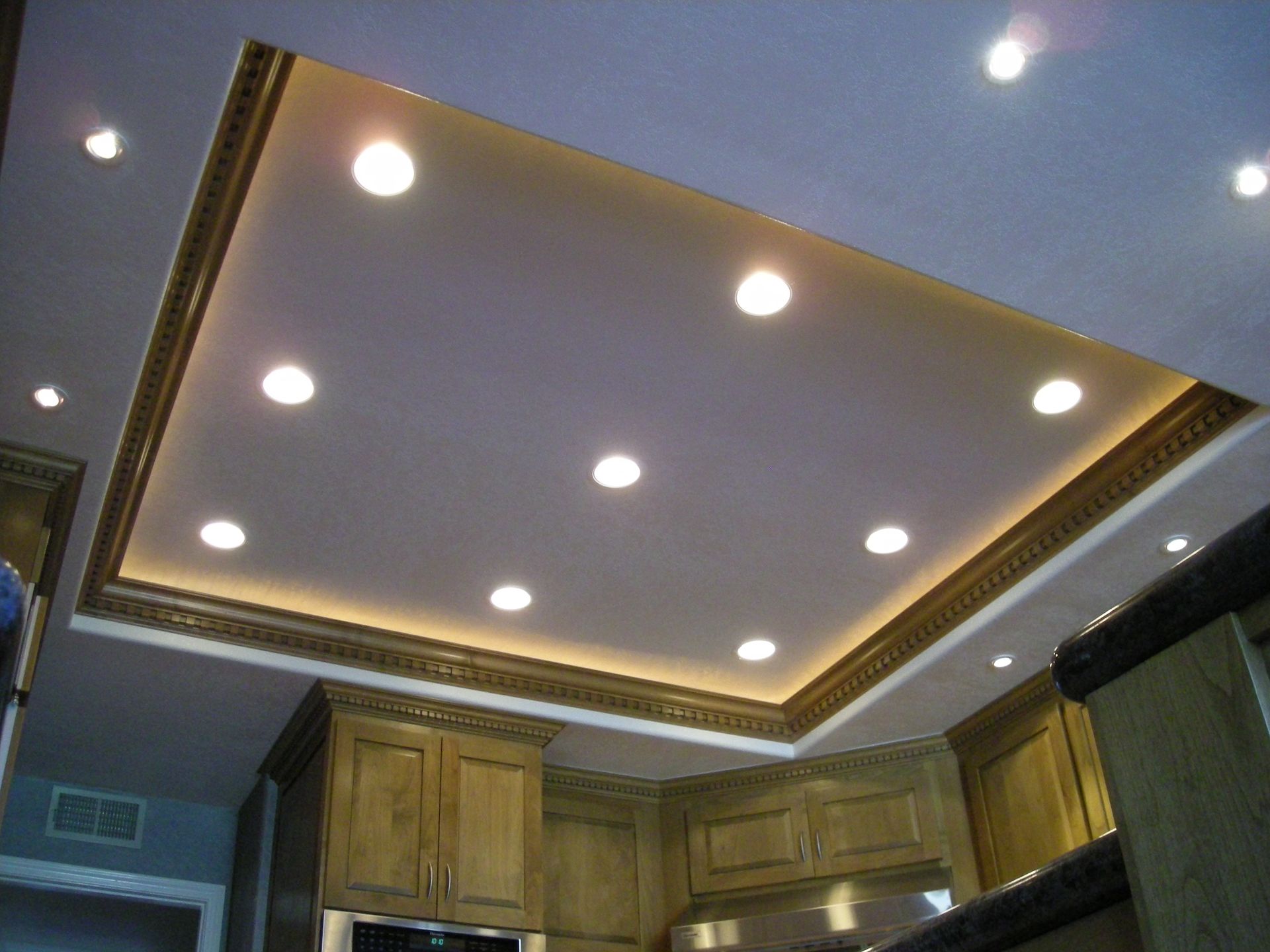 Kitchen ceiling with recessed lighting and decorative trim.