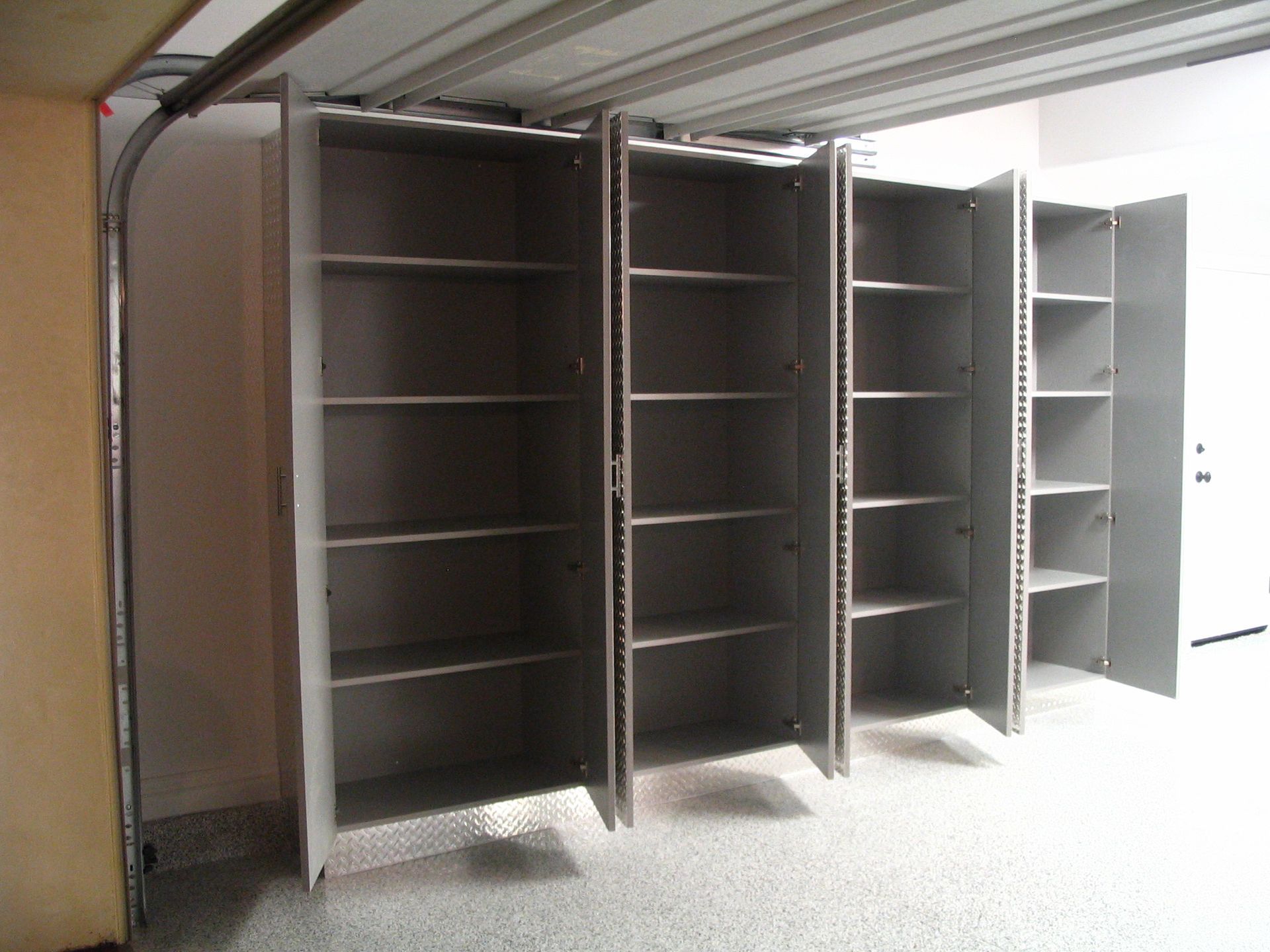 Gray storage cabinets with shelves in a garage.