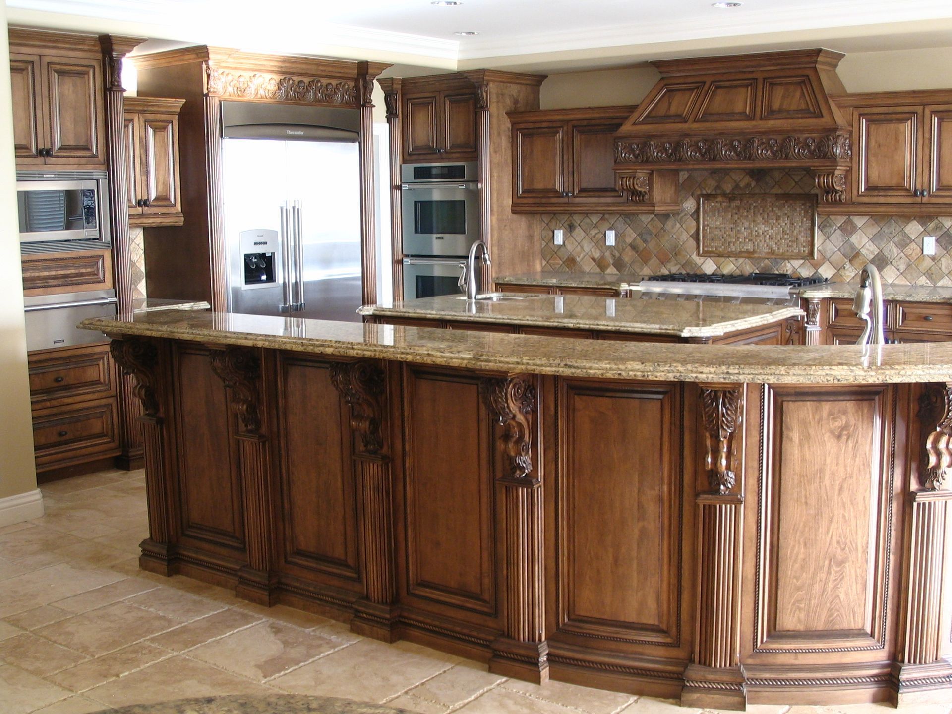 Luxurious kitchen with dark wood cabinets, granite countertops, and stainless steel appliances.