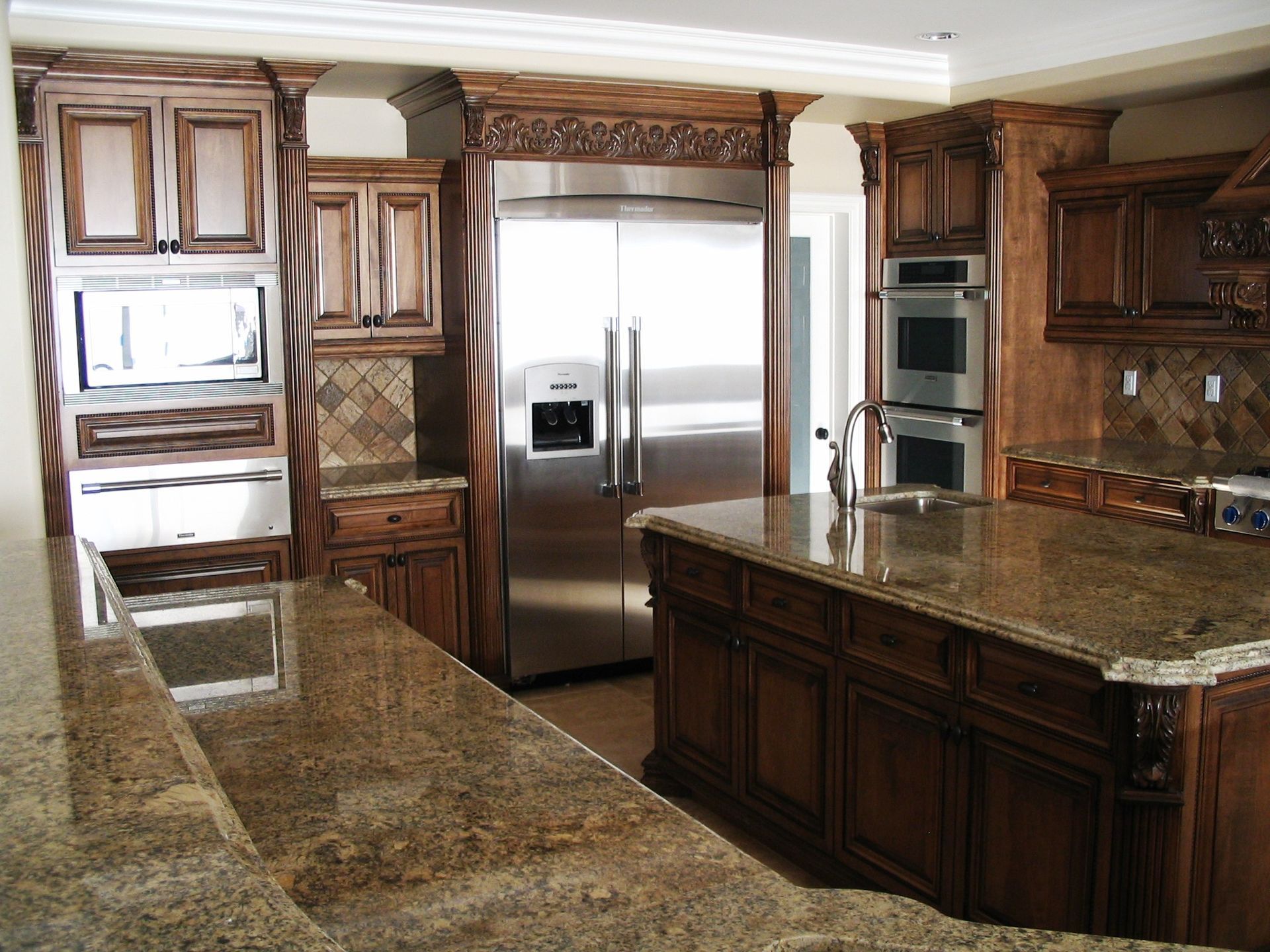 Kitchen with brown cabinets, granite countertops, and stainless steel appliances.