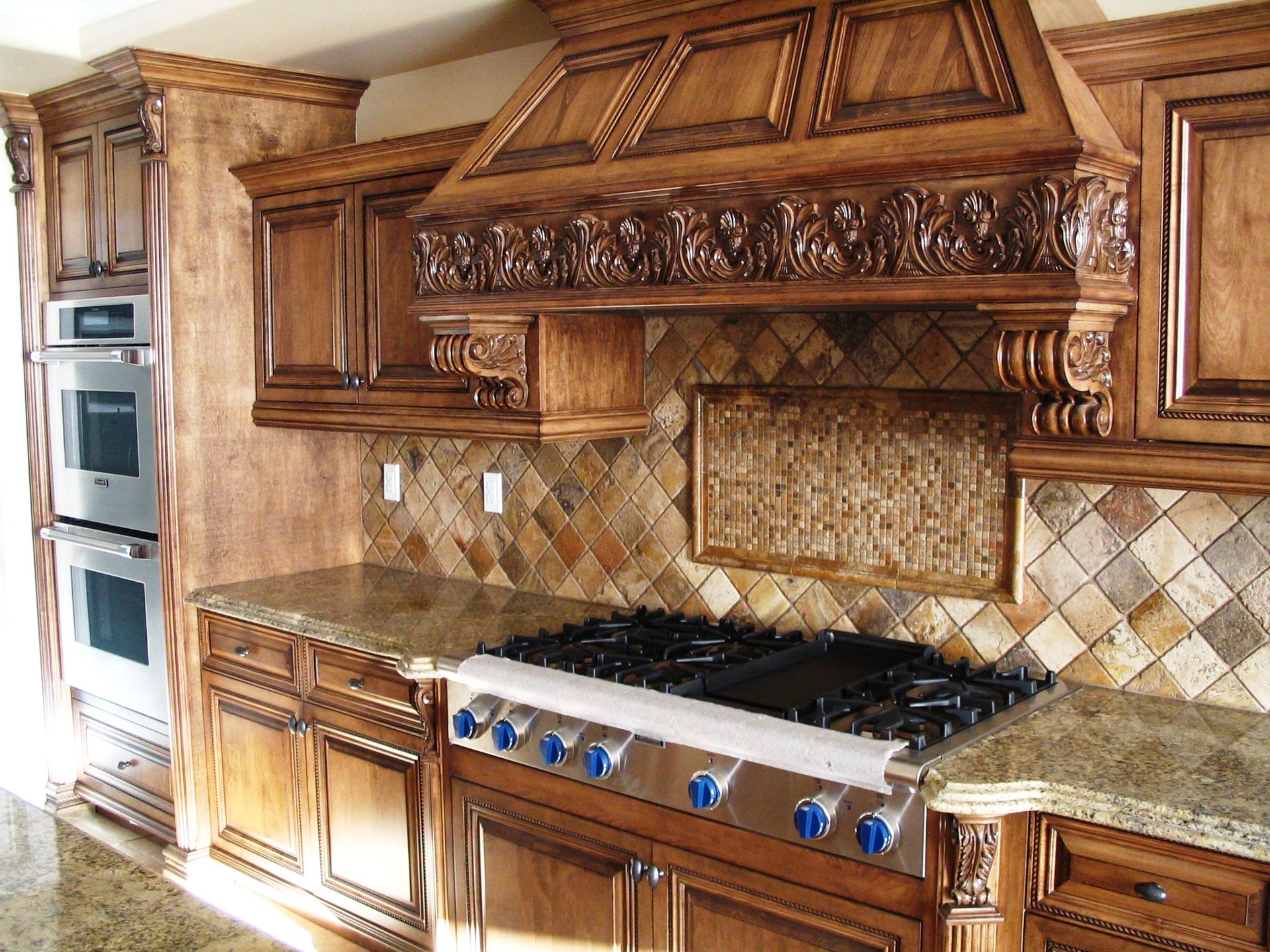 Wooden kitchen cabinets with granite countertops, stainless steel appliances, and decorative backsplash.