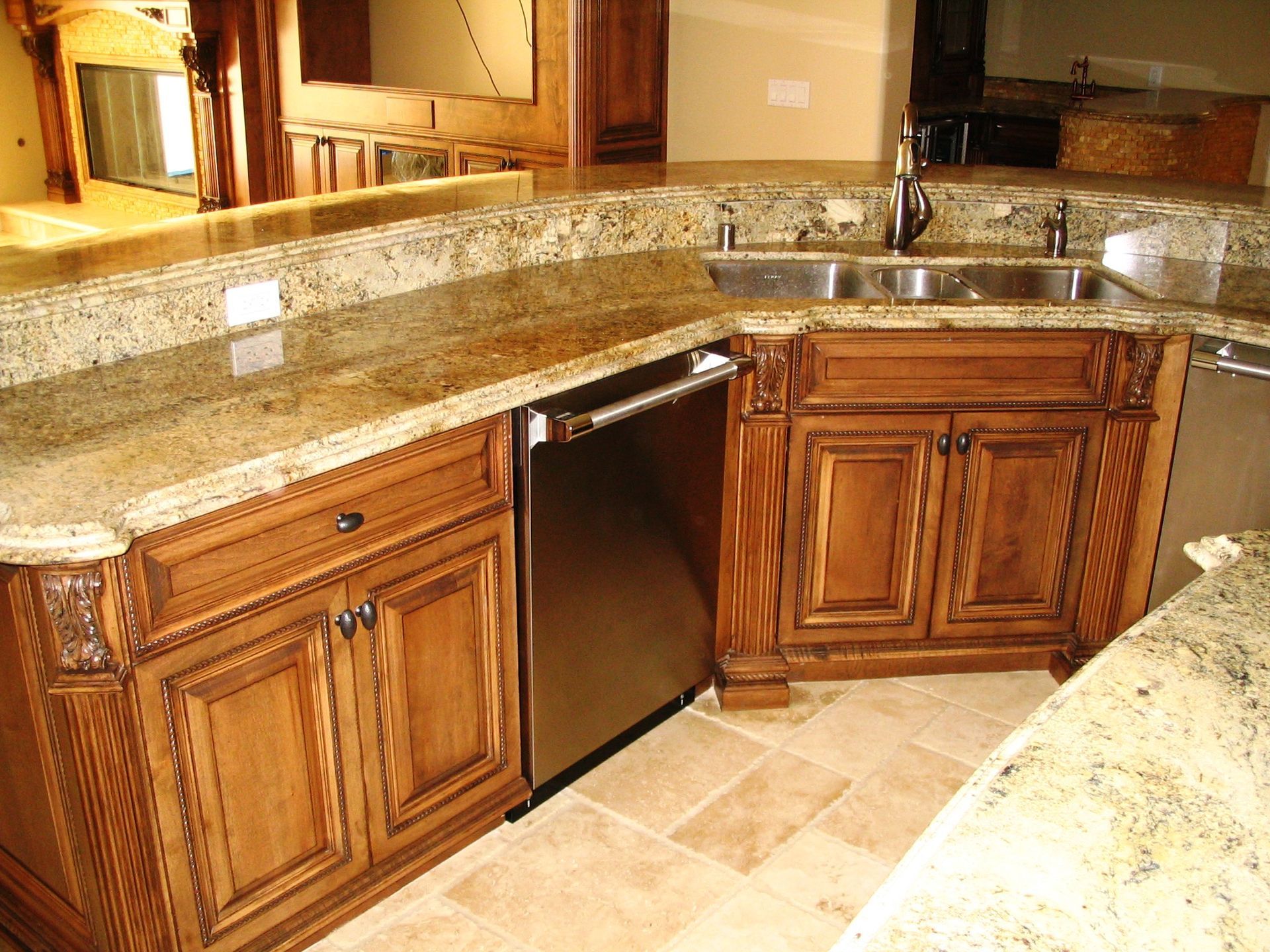 Kitchen with granite countertops and wooden cabinets. Stainless steel dishwasher and sink.