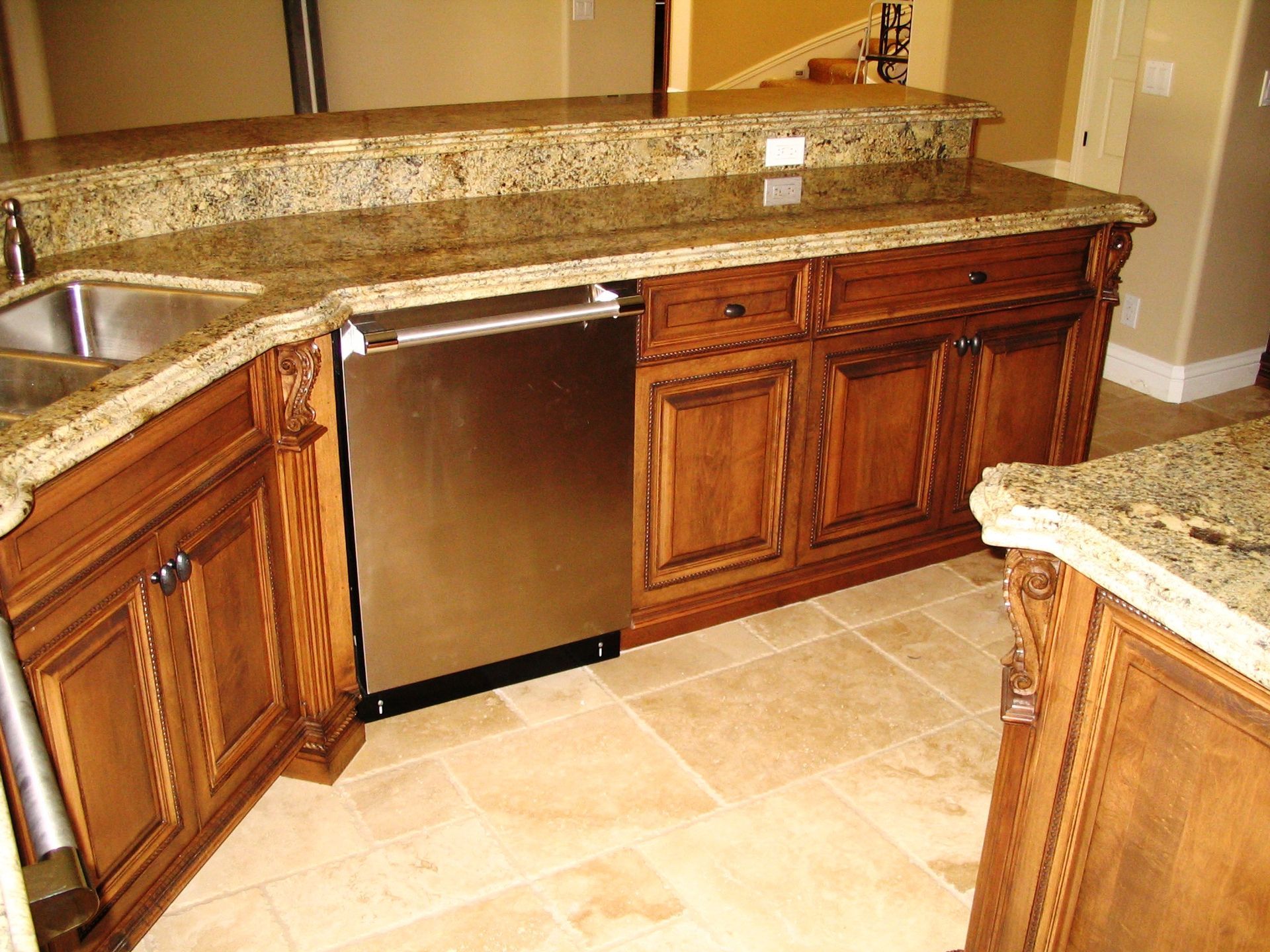Kitchen with wood cabinets, granite countertops, and stainless steel dishwasher.