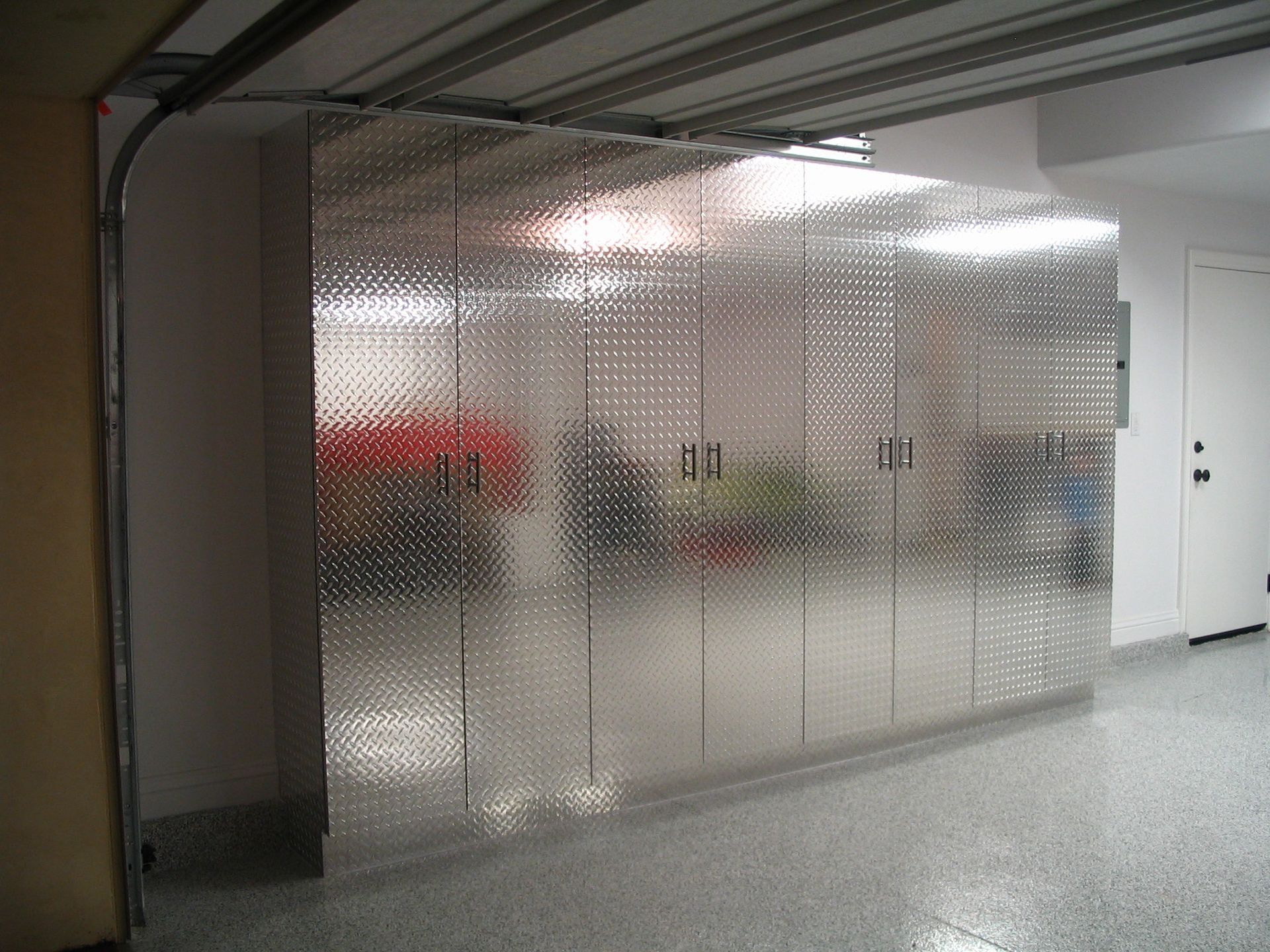 Garage interior with large, reflective storage cabinets, partially obscured behind the open garage door.