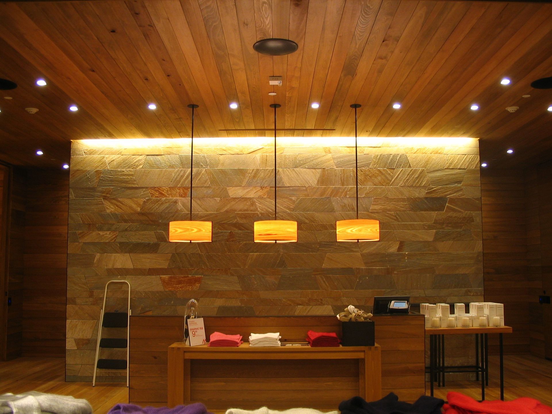 Retail space with wood and stone interior, pendant lights, and a display counter.