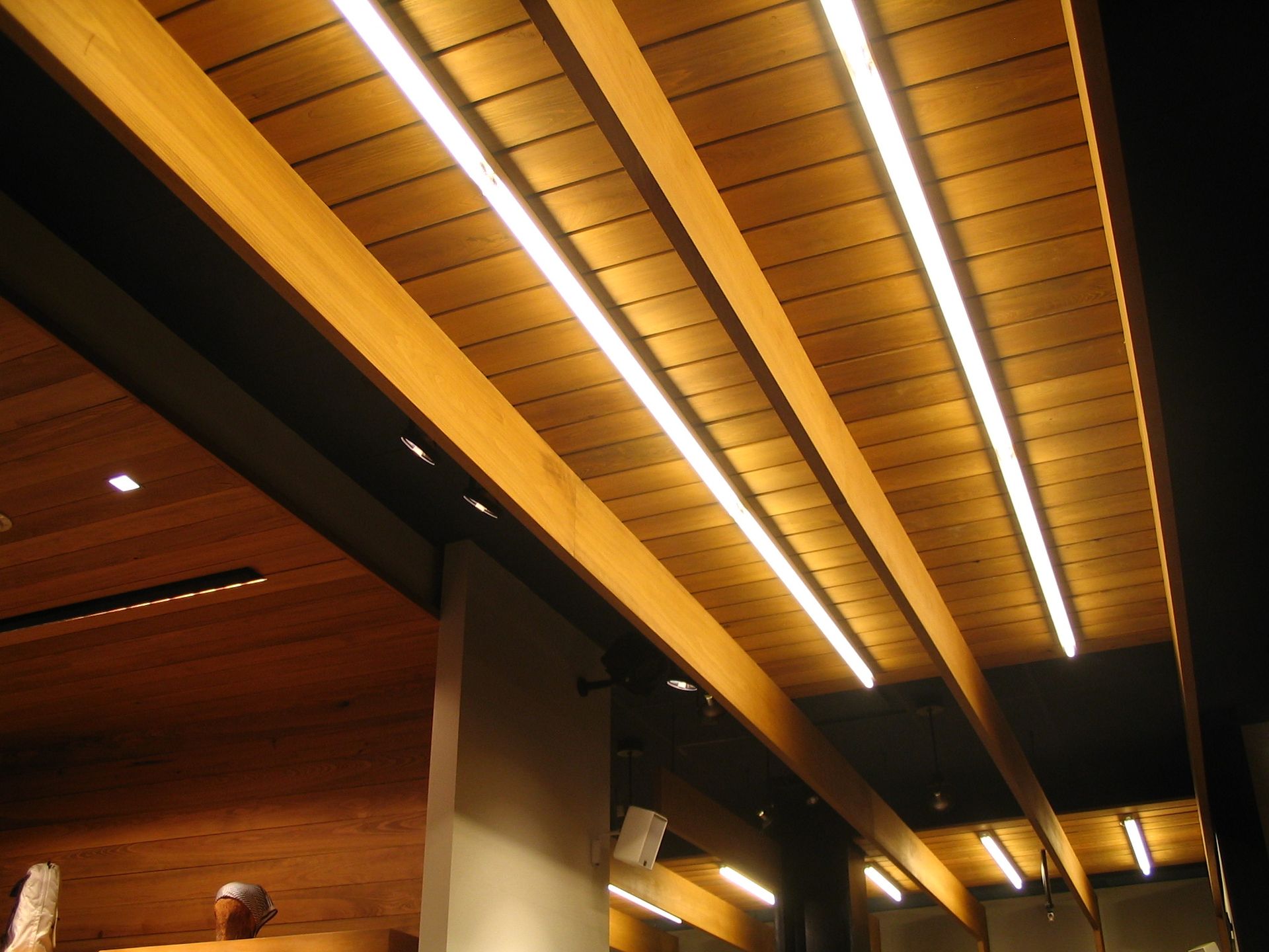 Wooden ceiling with recessed linear lights.