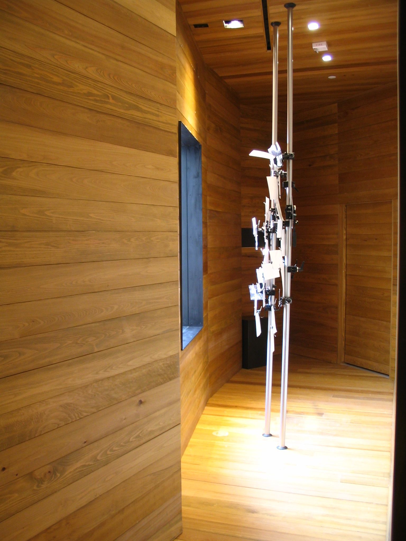 Wooden-paneled interior with sculptures; small window on the left.