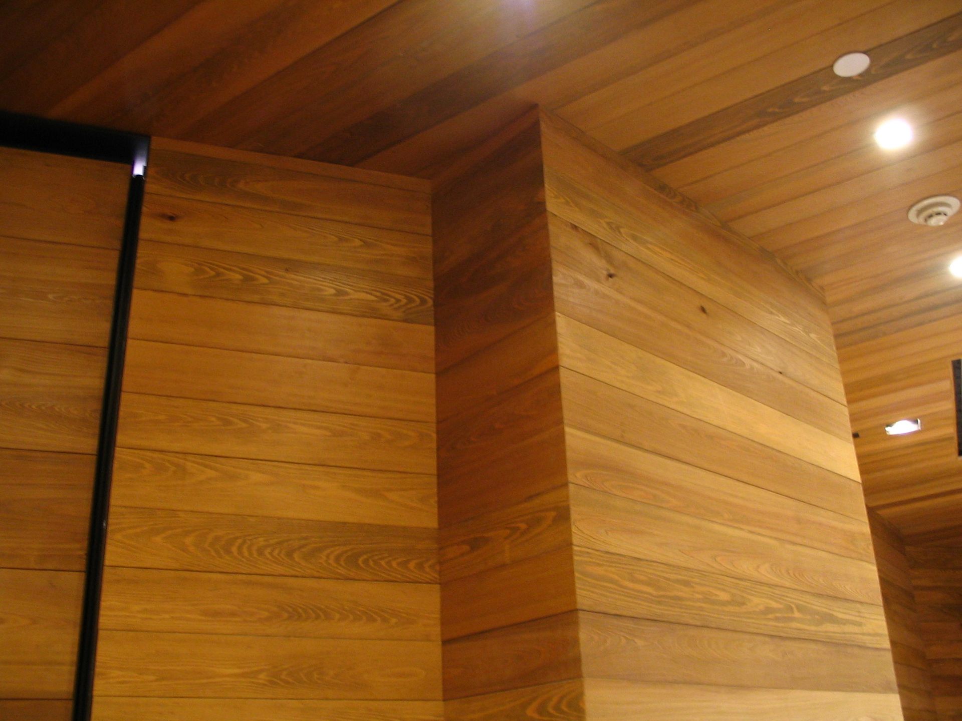Wooden walls and ceiling, with recessed lighting.