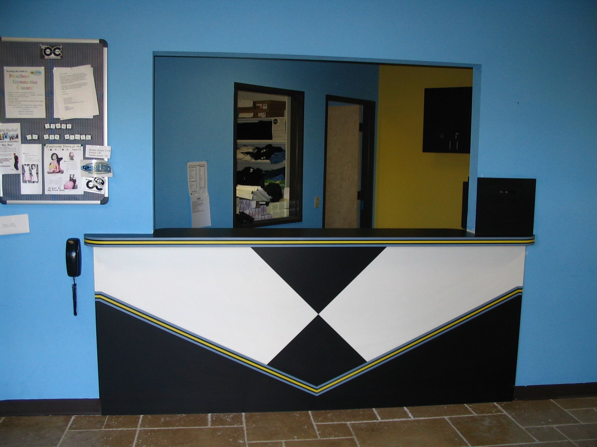 Reception desk with a white and black geometric design against a blue wall.