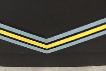 Chevron rank insignia. Pale blue and yellow stripes on a black background.