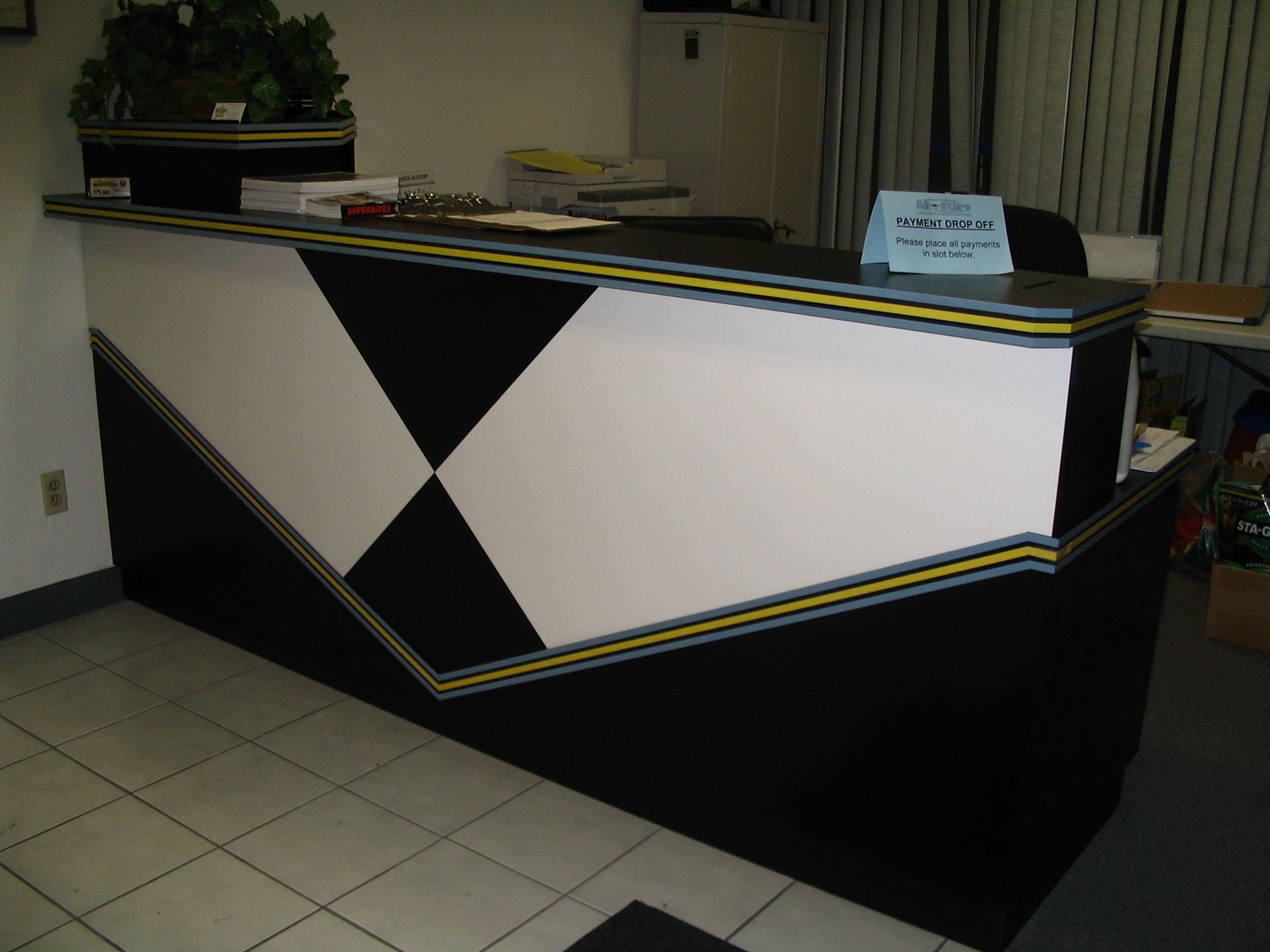 Geometric black and white reception desk with yellow trim.