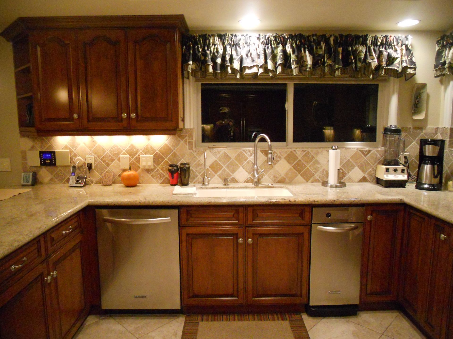 Kitchen with brown cabinets, granite countertops, and stainless steel appliances.