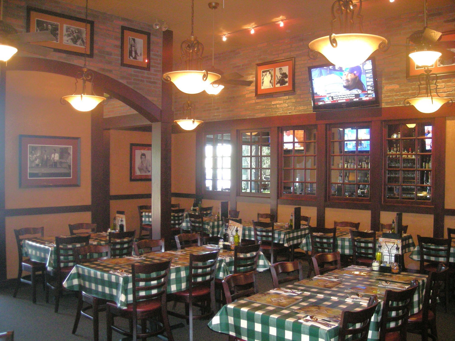 Built-in white media center with TV, fireplace, and shelves with wood backing; a person on screen.