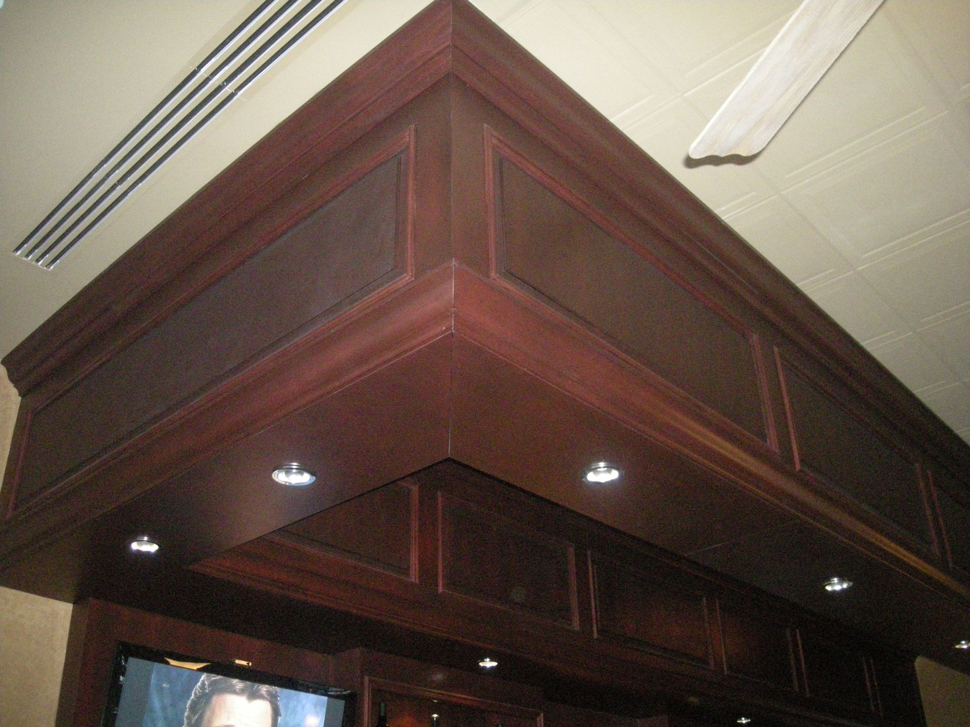 Dark wood corner trim with recessed lighting and panels.