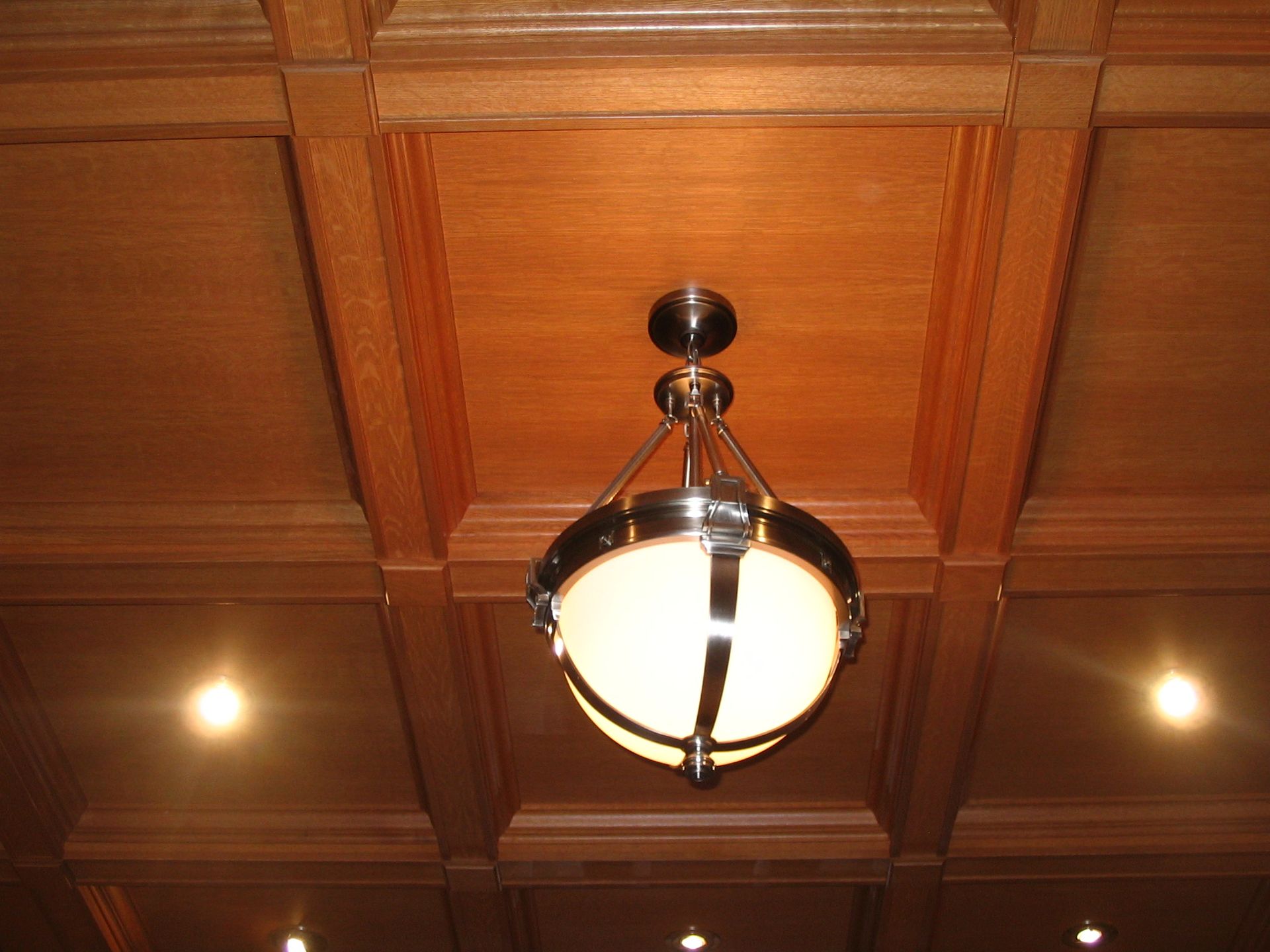 Wooden coffered ceiling with a circular light fixture.