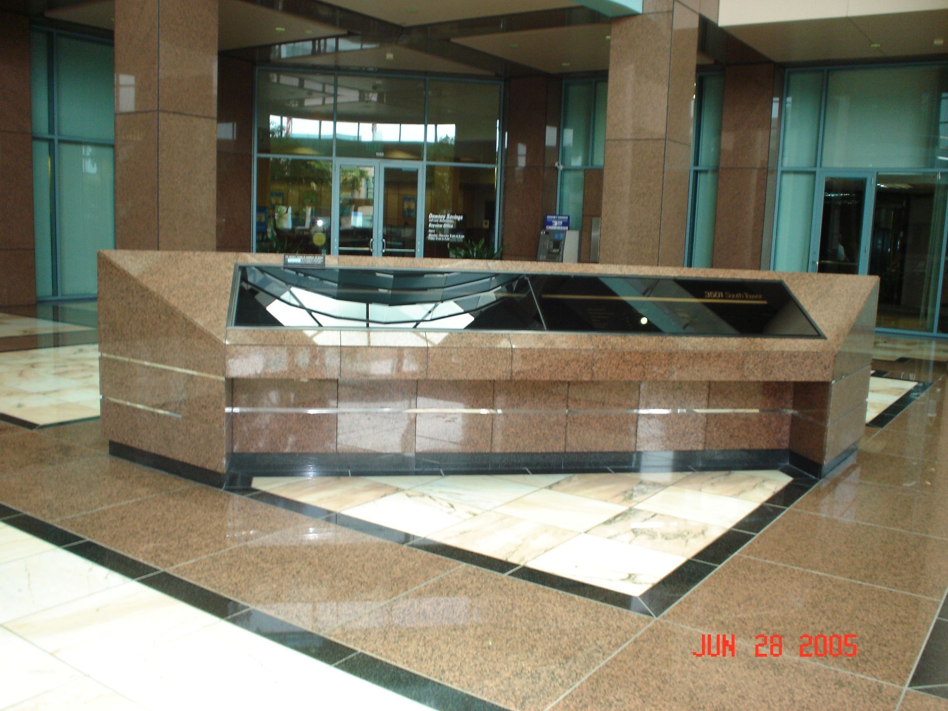 Triangular brown granite display case in a lobby.