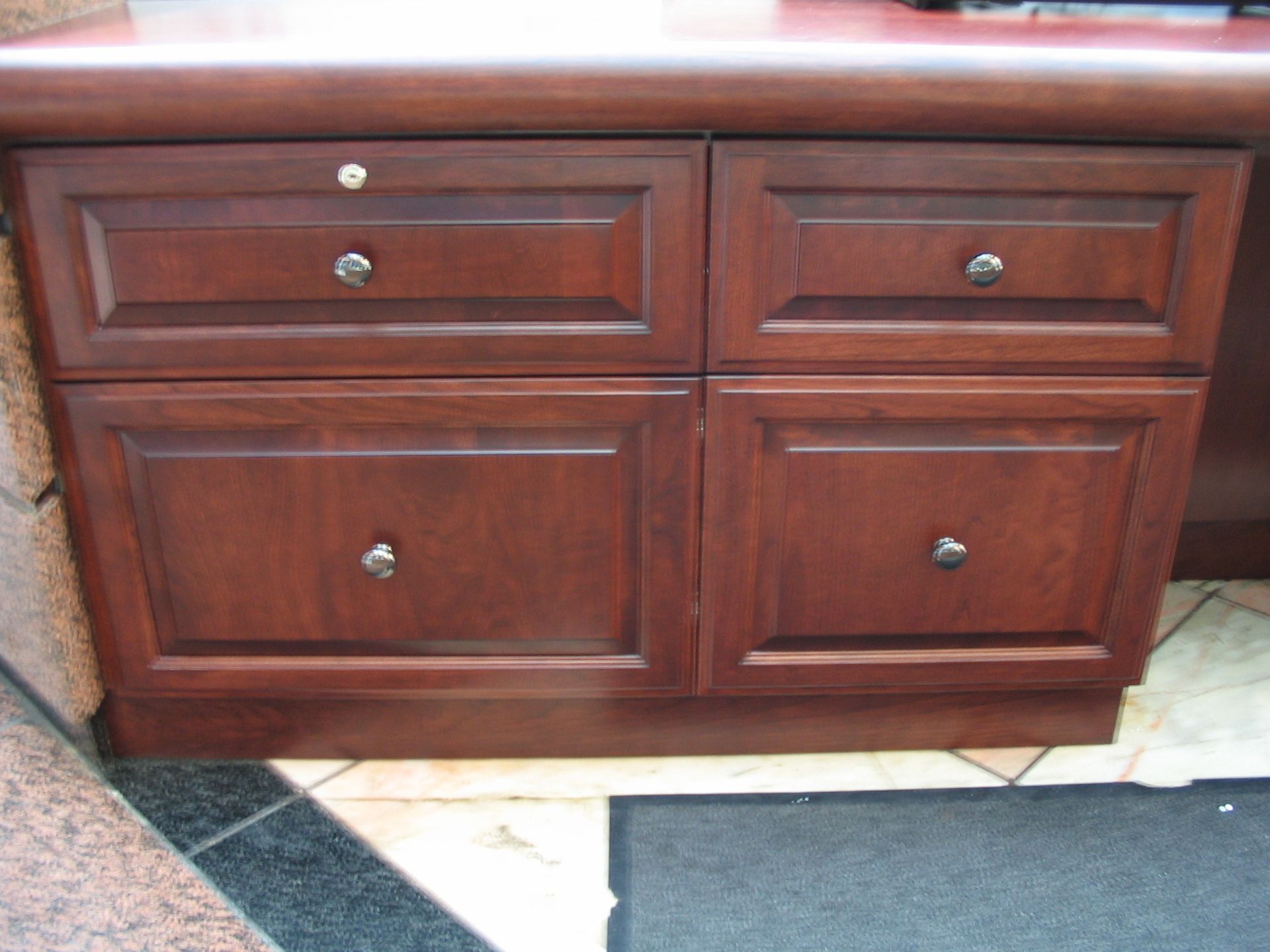 Wooden cabinet with four drawers, each with a silver knob.