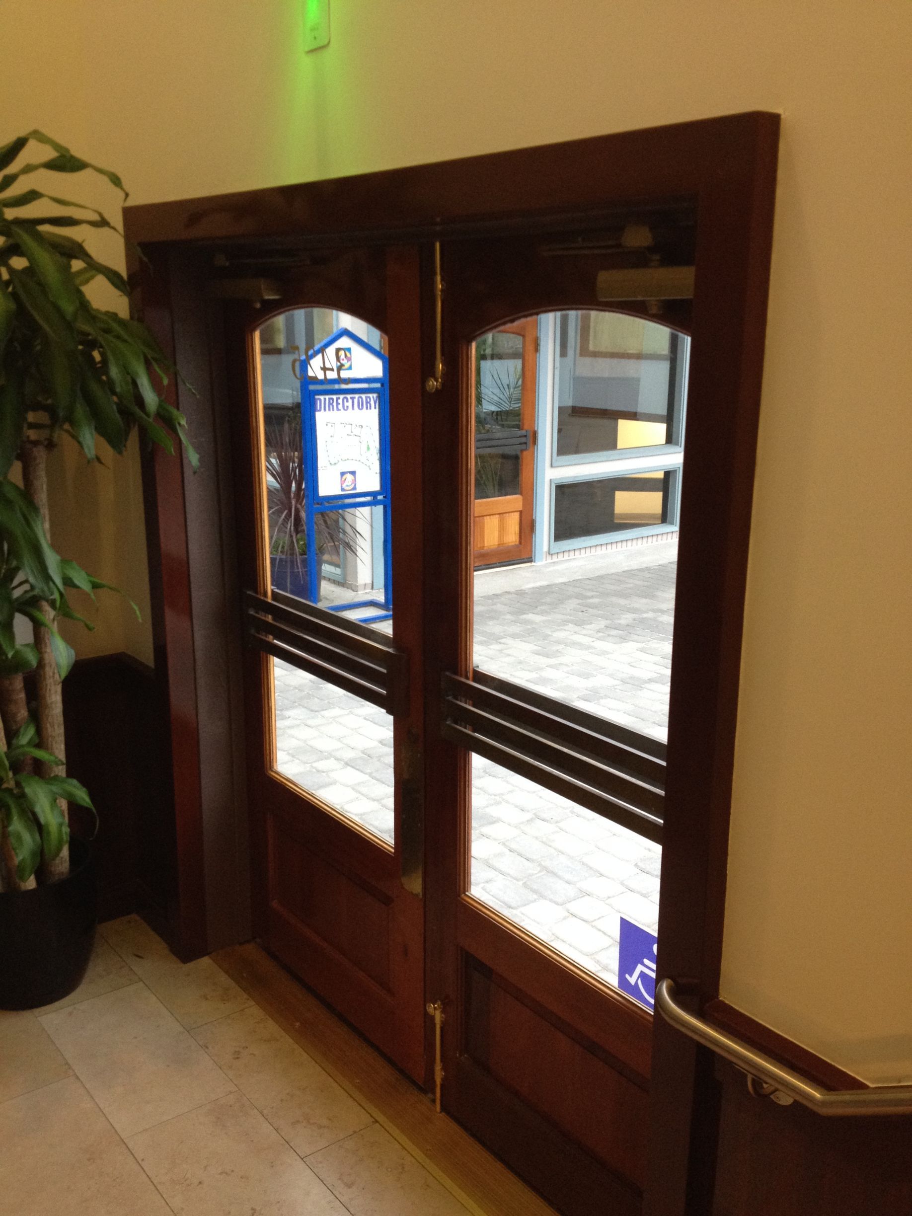 Double wooden doors with glass panes, brown frames, and horizontal bars.
