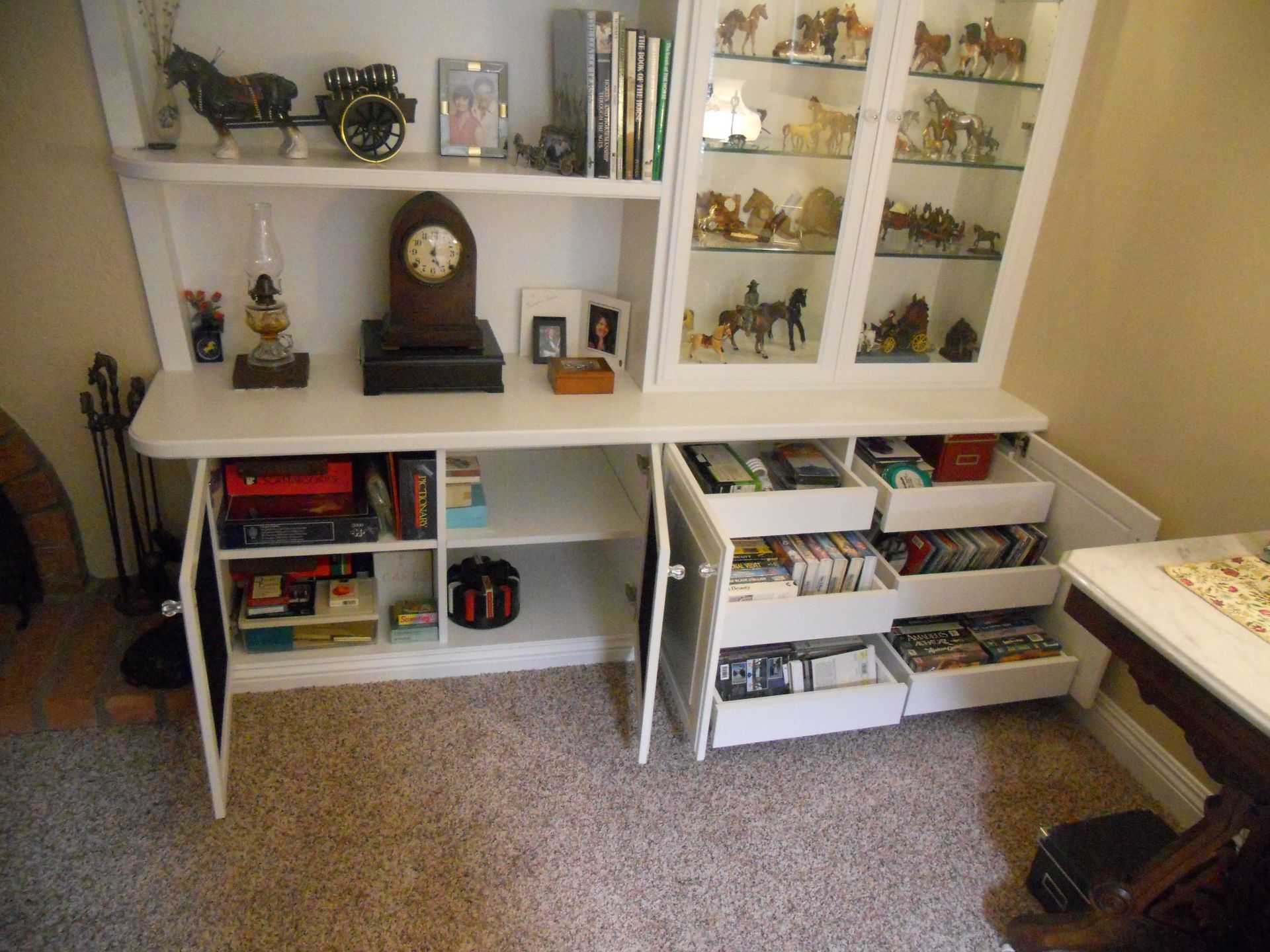 White hutch with open drawers and cabinet doors, displaying collectibles and storage.