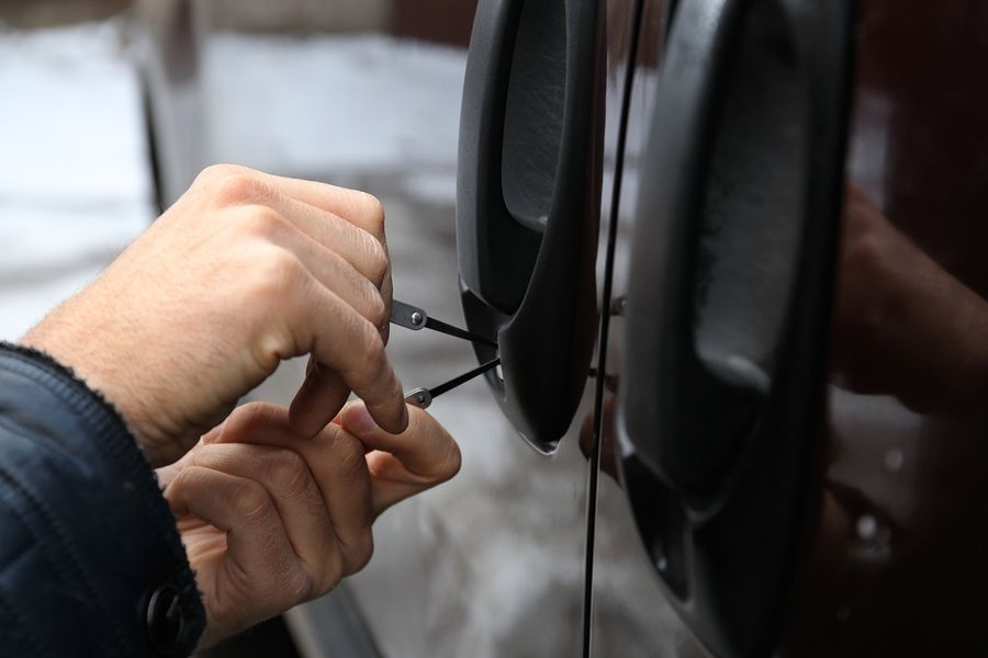 A man is using a key to open a car door.