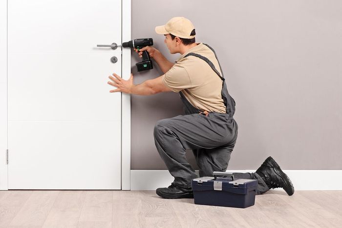 A man is installing a door with a drill.