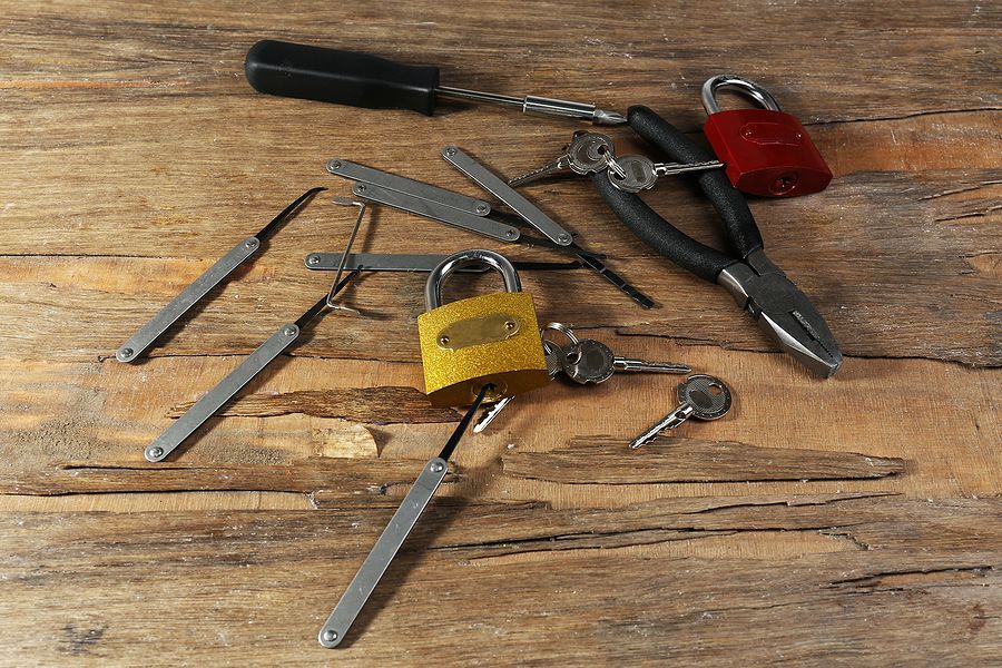 A bunch of tools on a wooden table including a padlock