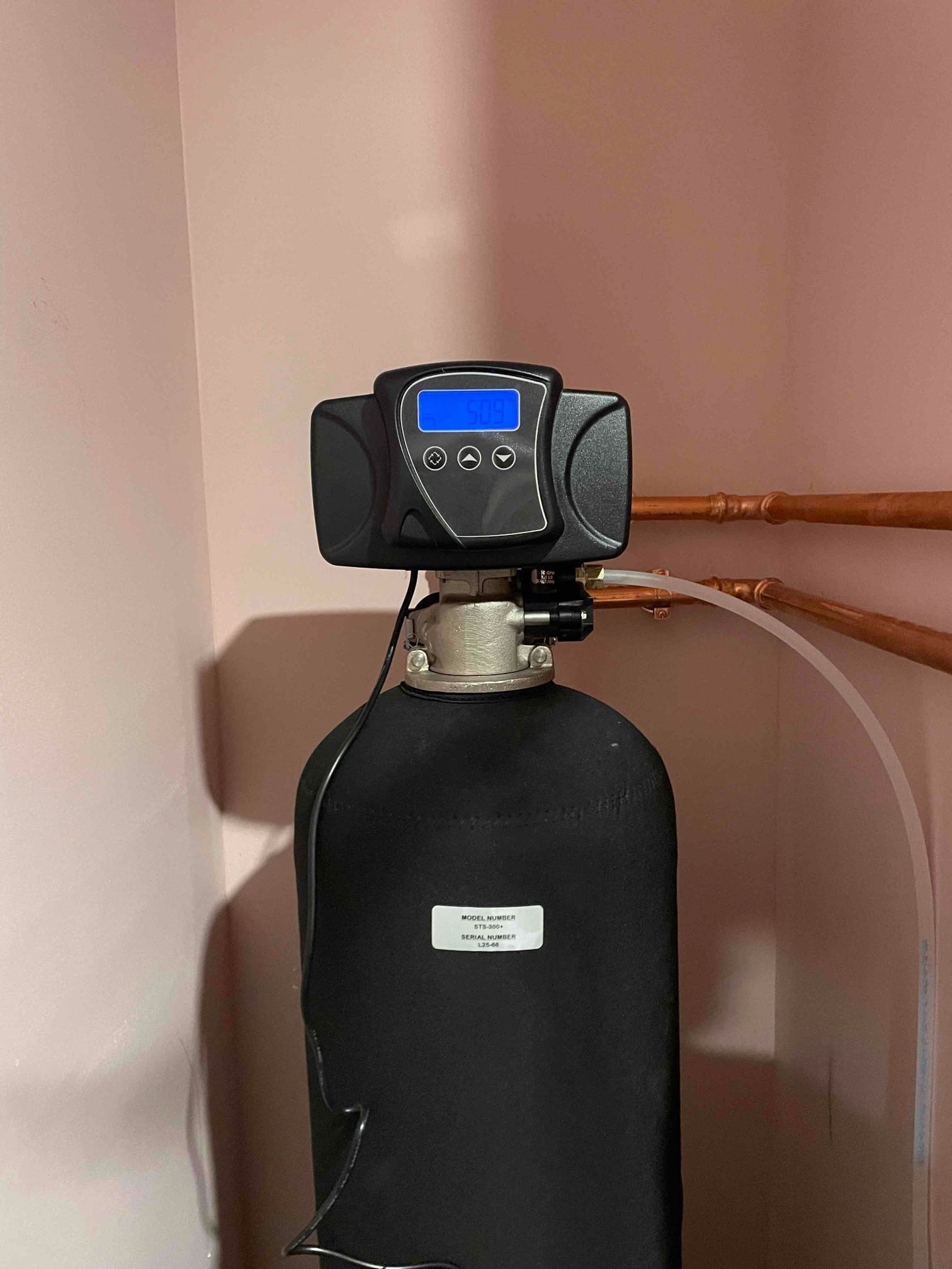 Plumbing pipes and fixtures under a bathroom sink. White and clear plastic piping, chrome fixtures.