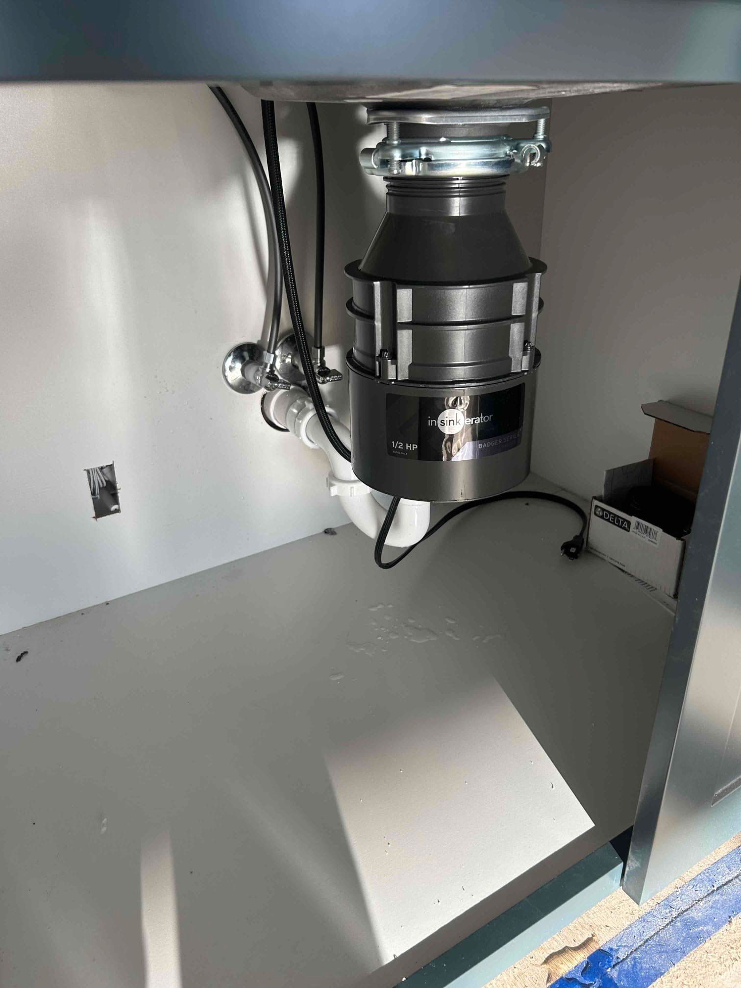An open dishwasher with empty racks, viewed from above, within a white kitchen cabinet.