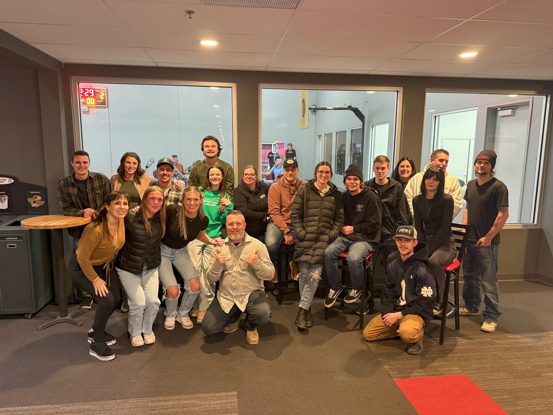 Group of people smiling, posing together inside a building.